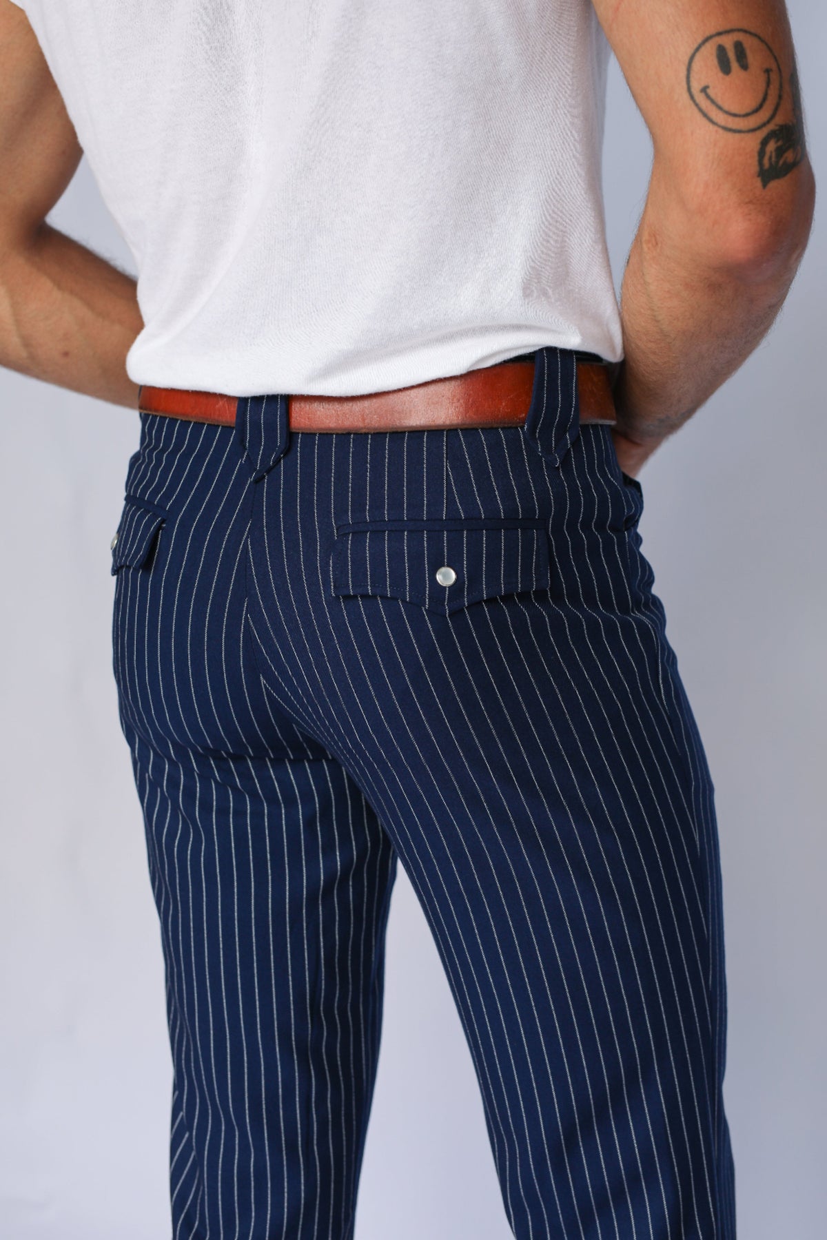 Back pocket close-up of the H Bar C Bakersfield navy pin stripe western pants with brown belt.