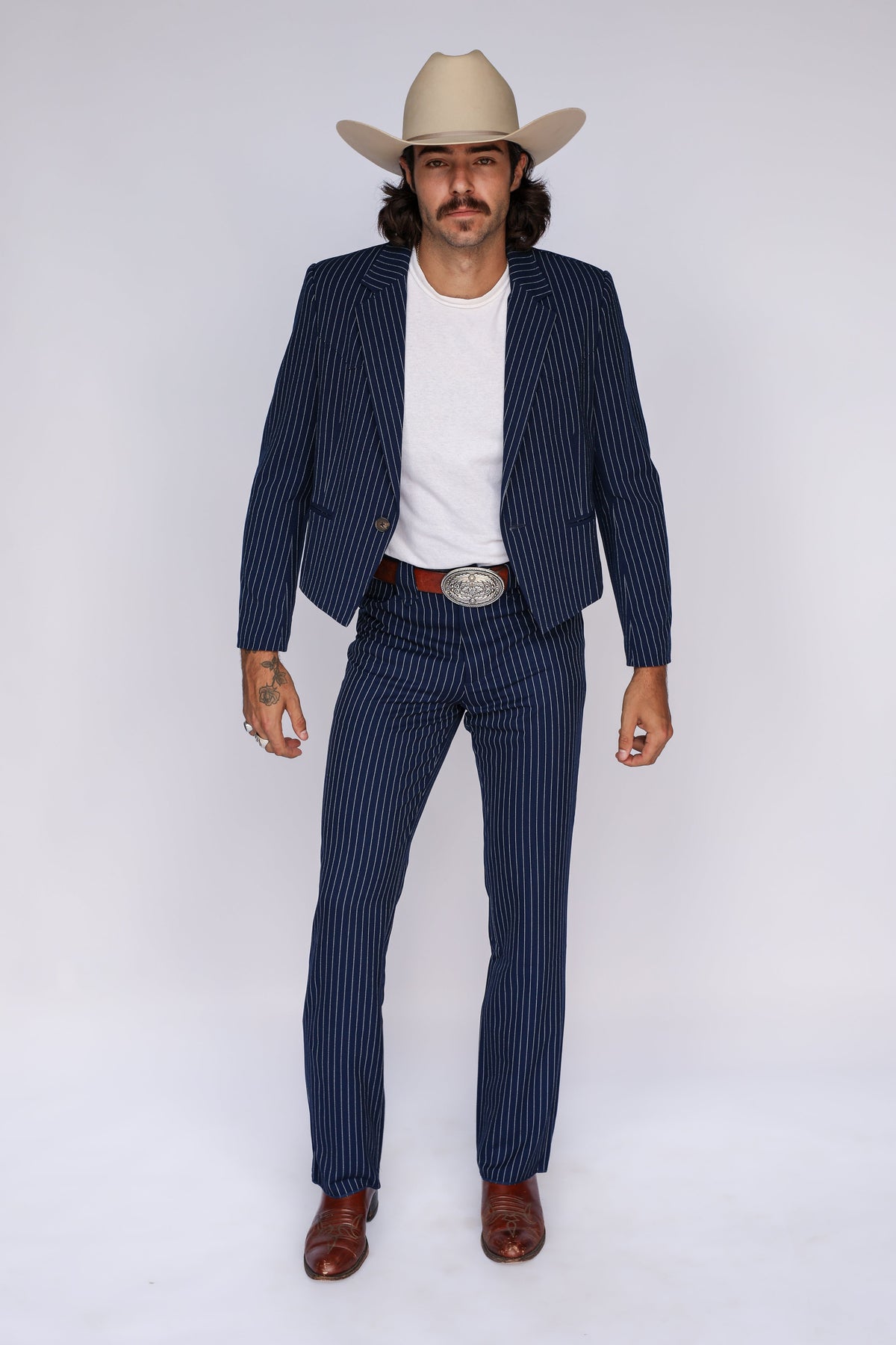 Man wearing the H Bar C Bakersfield navy pinstripe jacket and pants as a western suit with boots and cowboy hat.