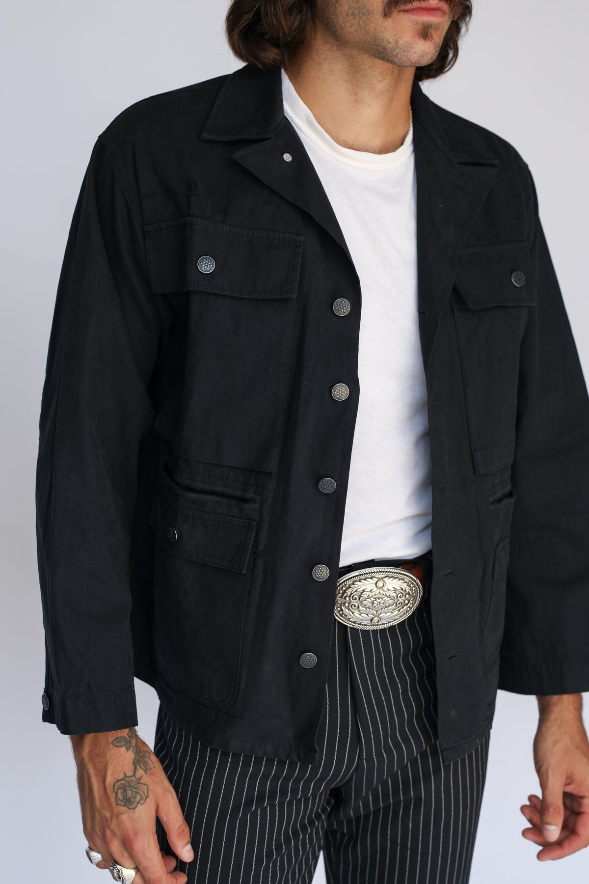 Front view of the H Bar C Normandy black chore coat with pinstripe pants and silver buckle.