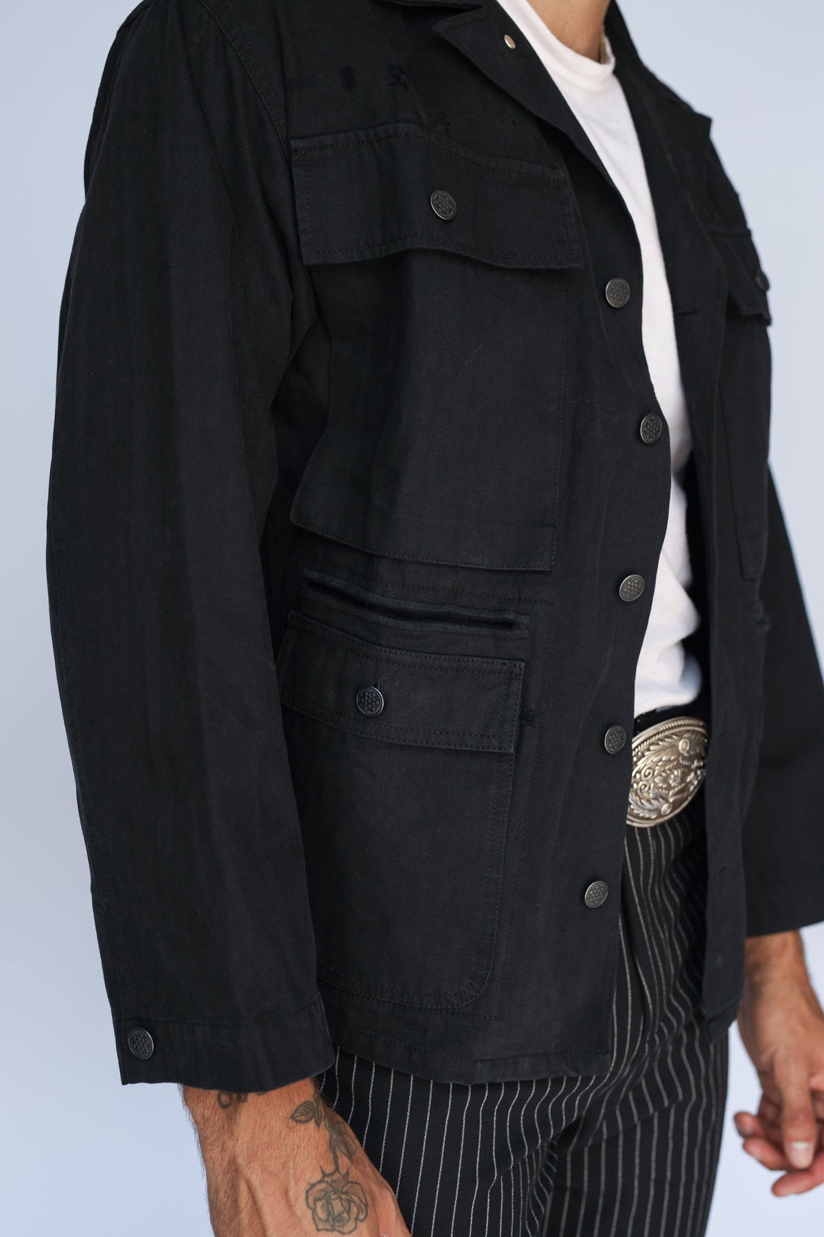 Detail of the H Bar C Normandy black utility chore coat with a silver western buckle.