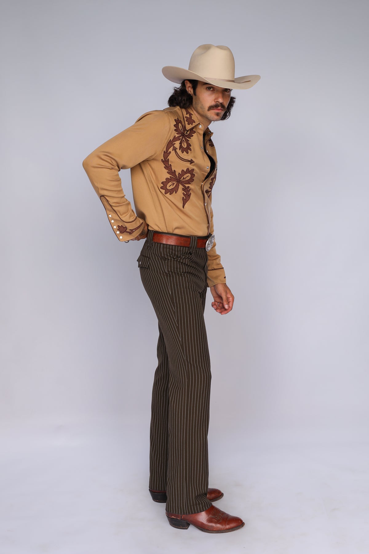 Man wearing the H Bar C Terlingua western shirt with the Bakersfield brown pinstripe pants and a cowboy hat.