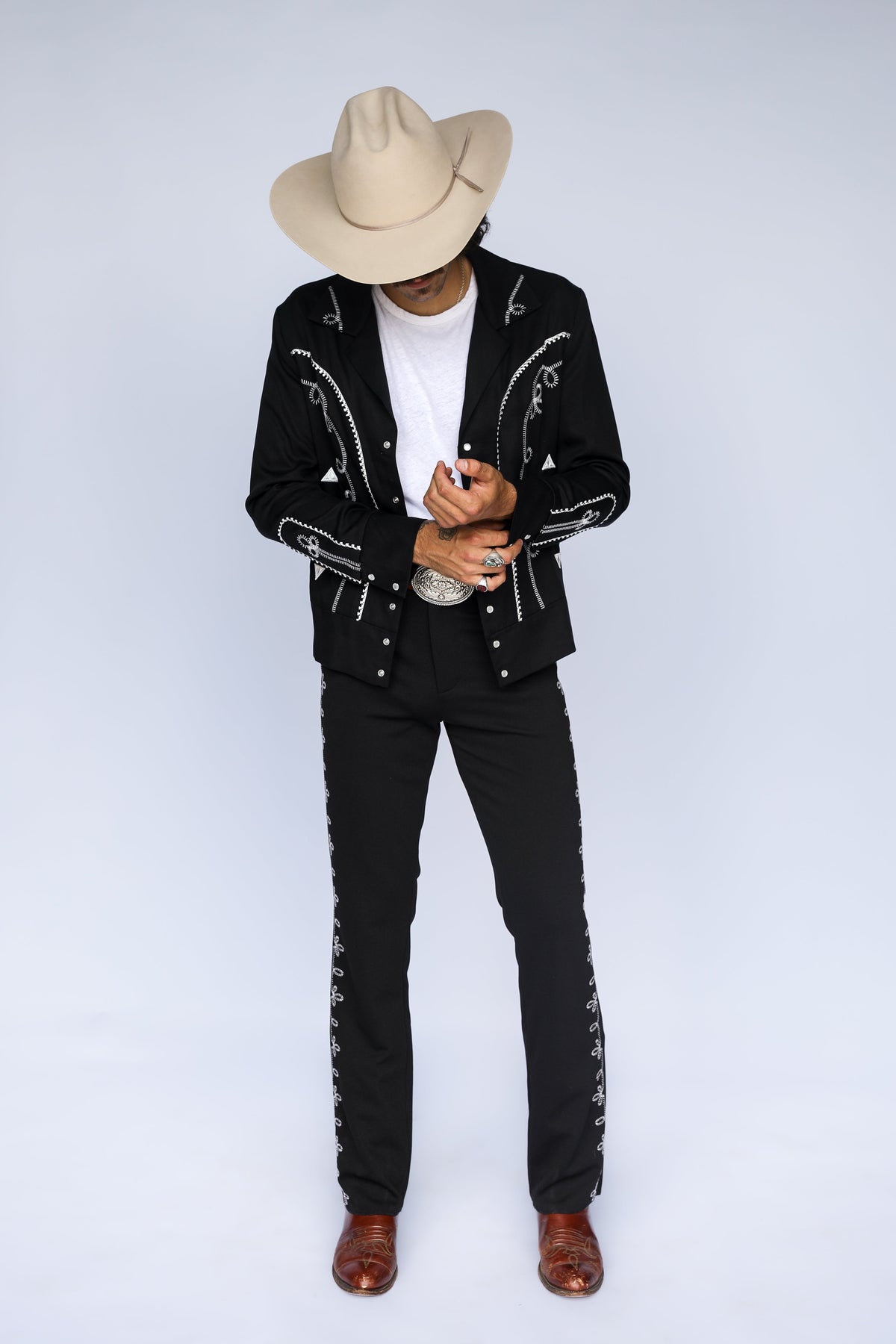Full length view of the H Bar C Bolero black and white jacket and Bolero pants worn as a western suit with cowboy hat and boots.