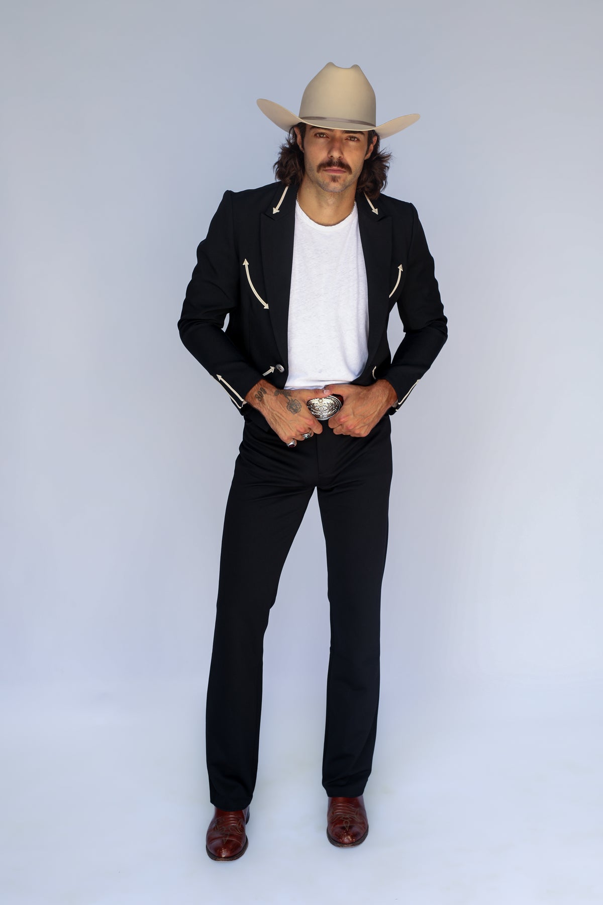 Full length view of the H Bar C Calamity men's black jacket styled as a western suit with black pants, boots, and a cowboy hat.