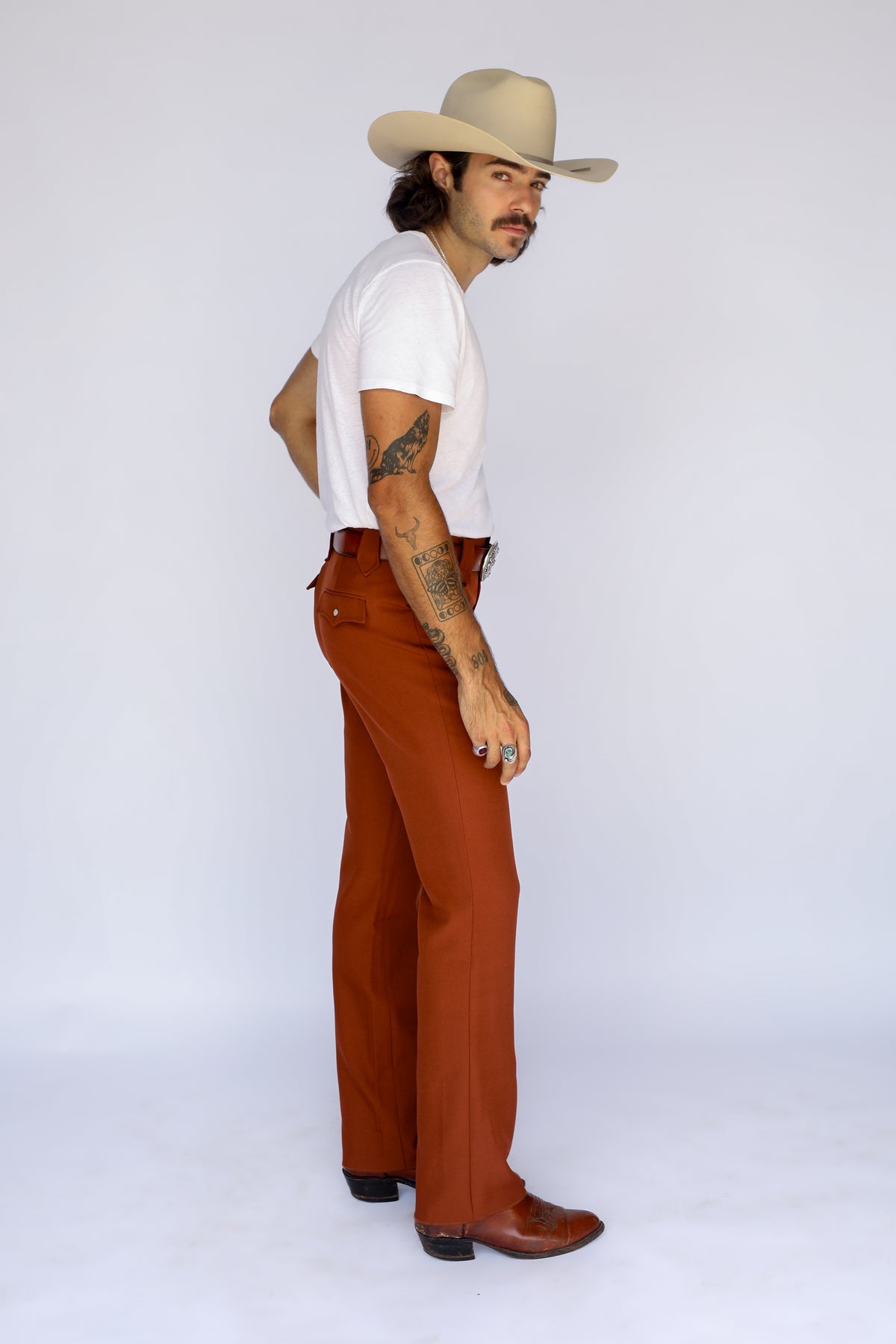 Side profile of a man in a cowboy hat wearing the H Bar C Franklin brown western pants.