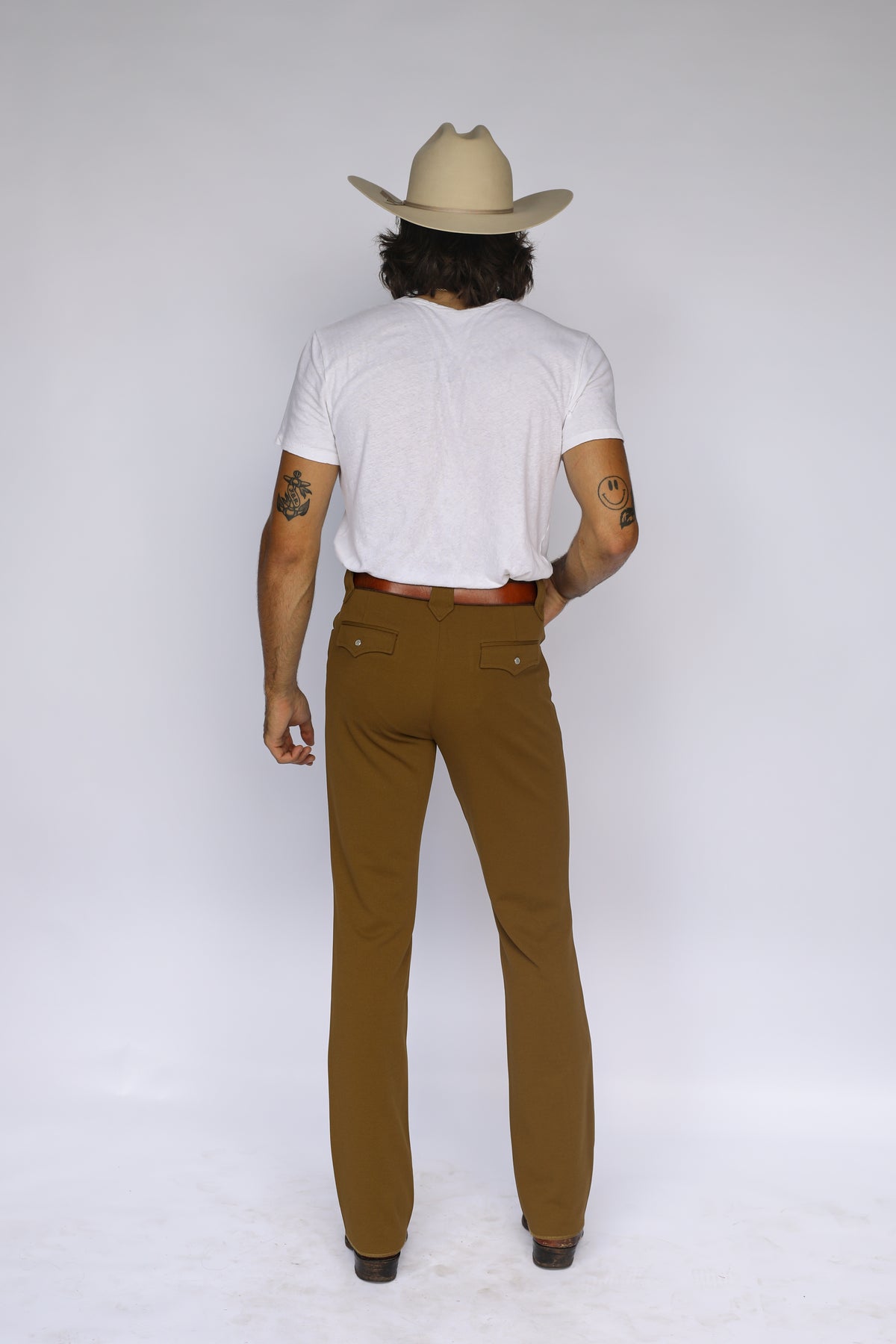 Back view of a man in a cowboy hat wearing the H Bar C Franklin olive green western pants.