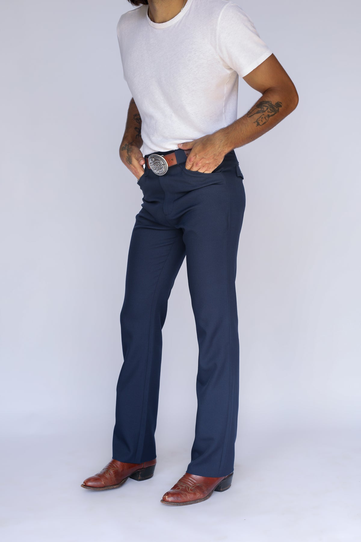 Three-quarter view of the H Bar C Franklin navy western pants with a white tee and brown boots.