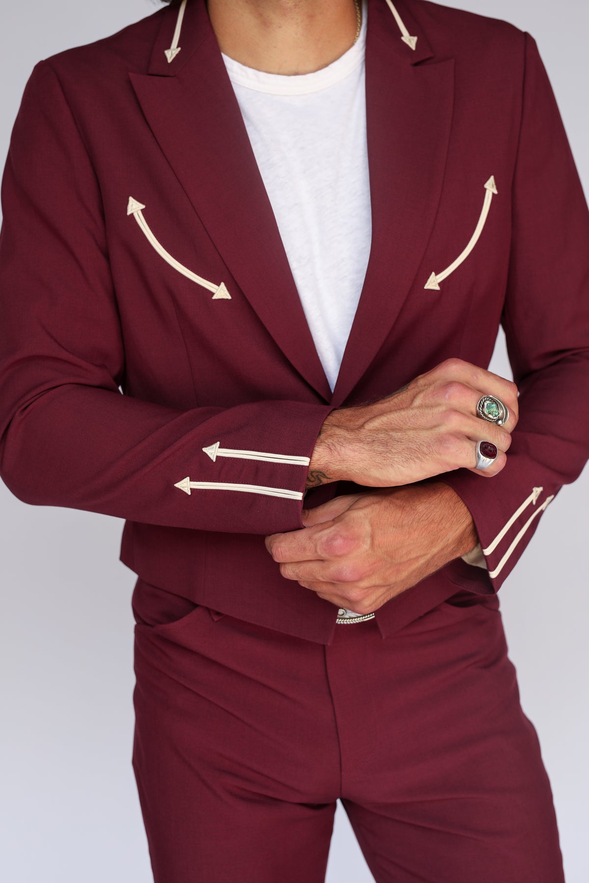 Detail of the cream piped arrow pockets and cuff on the H Bar C Calamity men's maroon jacket.