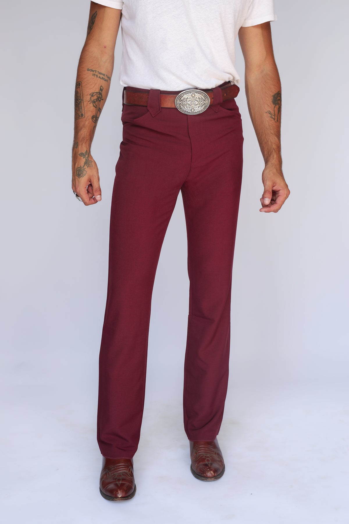 Front view of the H Bar C Calamity unisex western pants in maroon, a stretch western dress pant worn with a silver buckle.