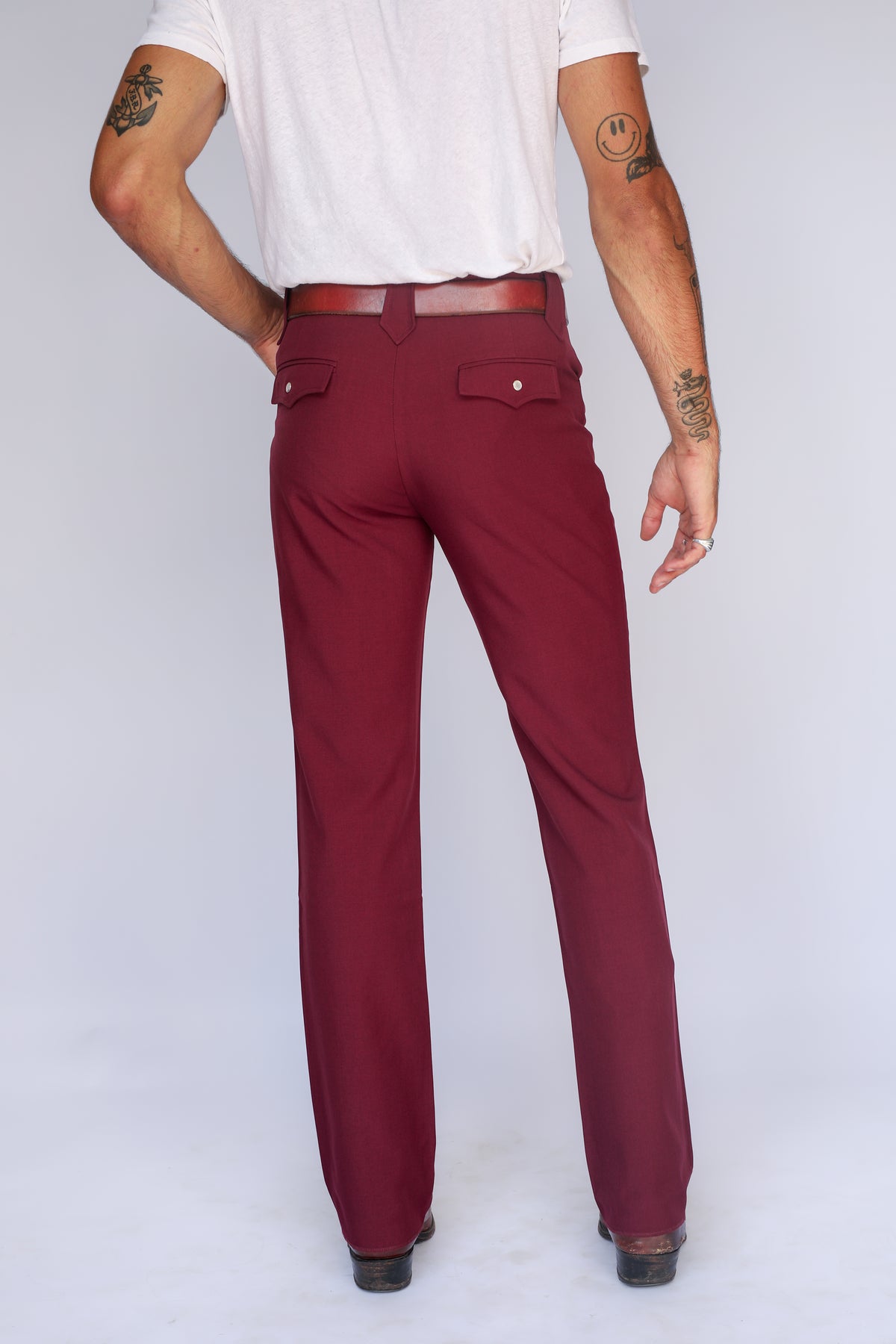 Back view of the H Bar C Calamity unisex maroon western pants with a white tee and brown belt.