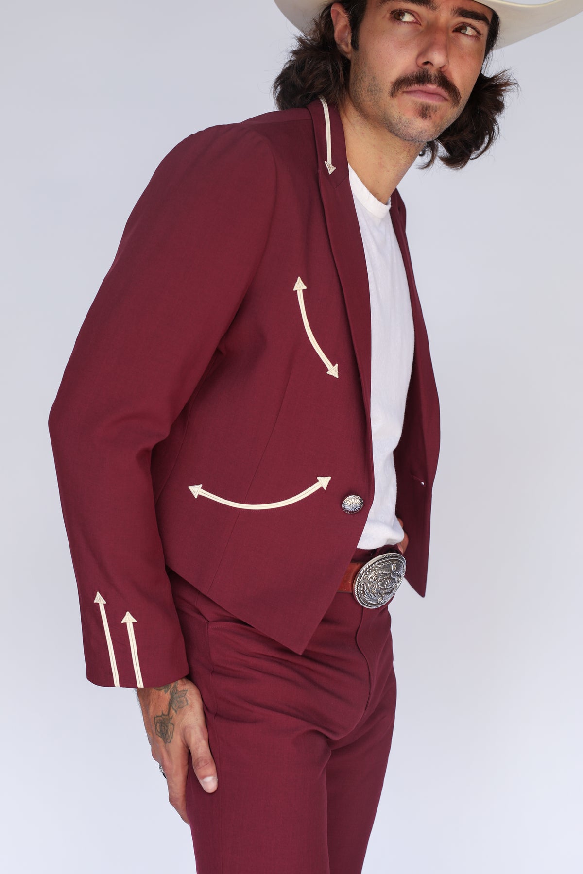 Man wearing the H Bar C Calamity men's jacket in maroon with cream arrow details, a western tuxedo blazer.