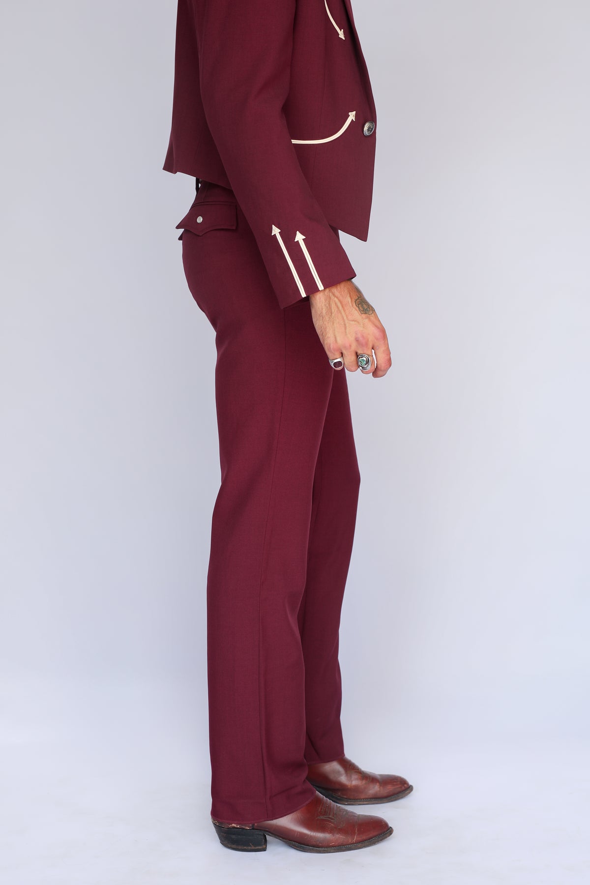Side view of the H Bar C Calamity maroon jacket and pants with cream arrow cuff details.