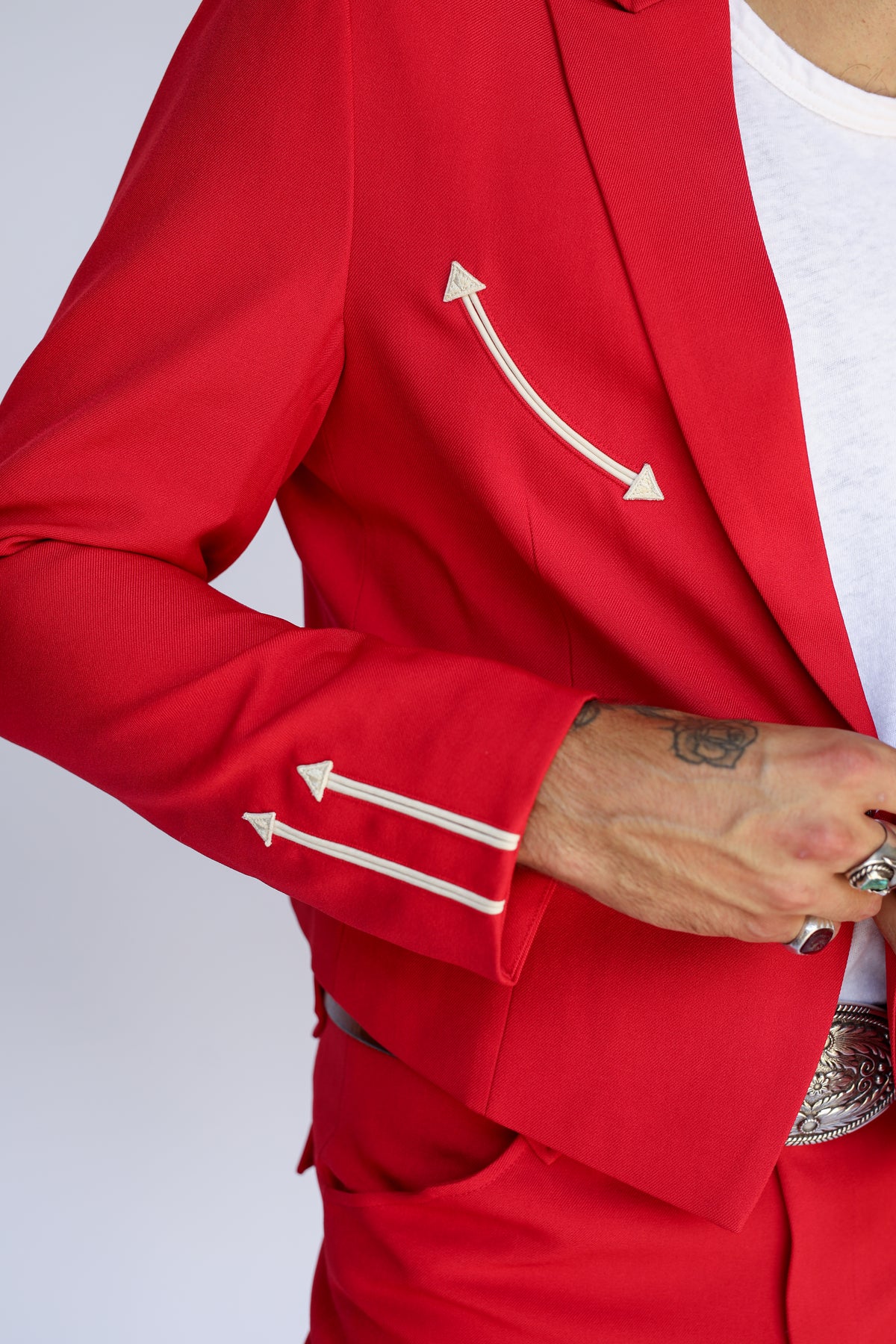 Sleeve detail of the H Bar C Calamity red jacket with cream embroidered arrows.