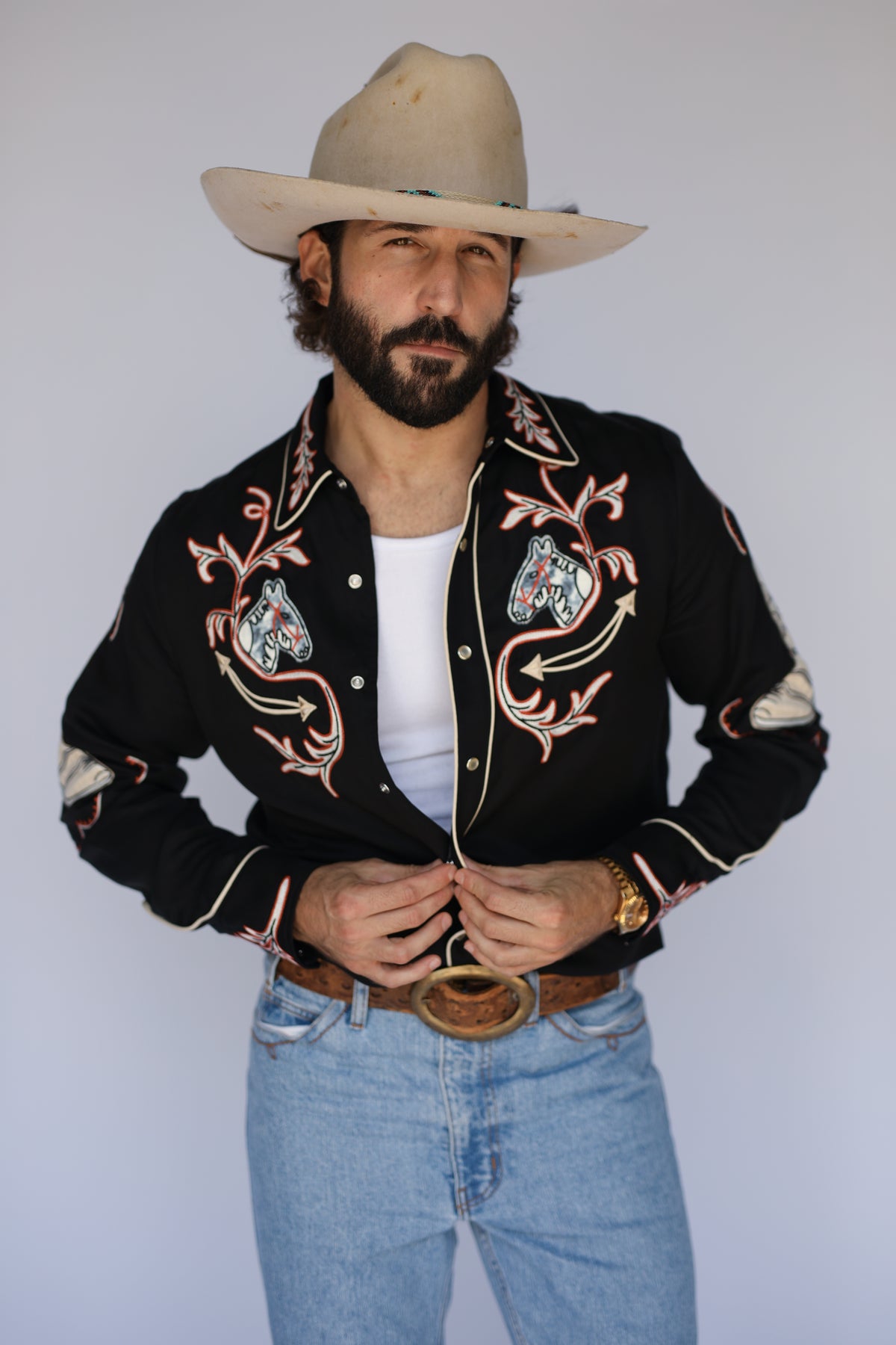 Man in a cowboy hat wearing the H Bar C Calabasas shirt in black, a 1940s remake with multicolor chain stitch embroidery.