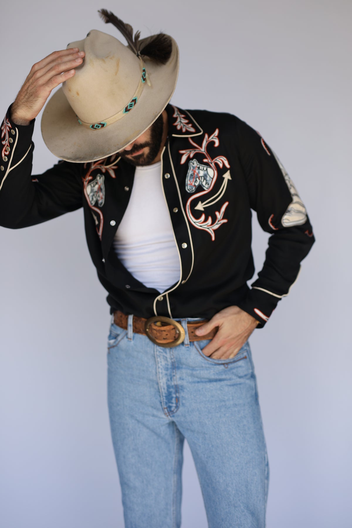 Man tipping his cowboy hat in the H Bar C Calabasas black chain stitch shirt.