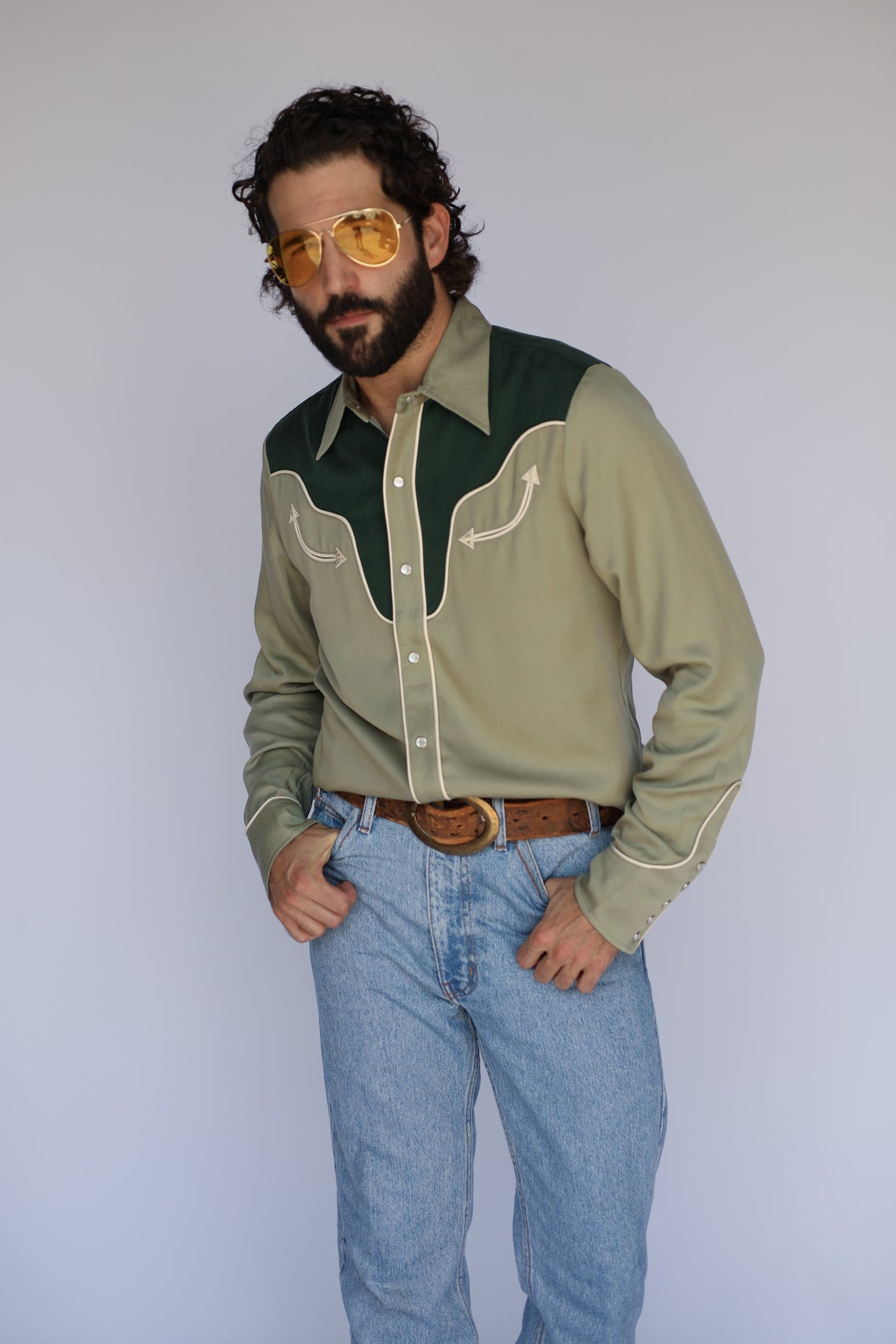 Three-quarter view of the H Bar C San Juan men's green pearl snap shirt with dark green yoke and rodeo cuffs.