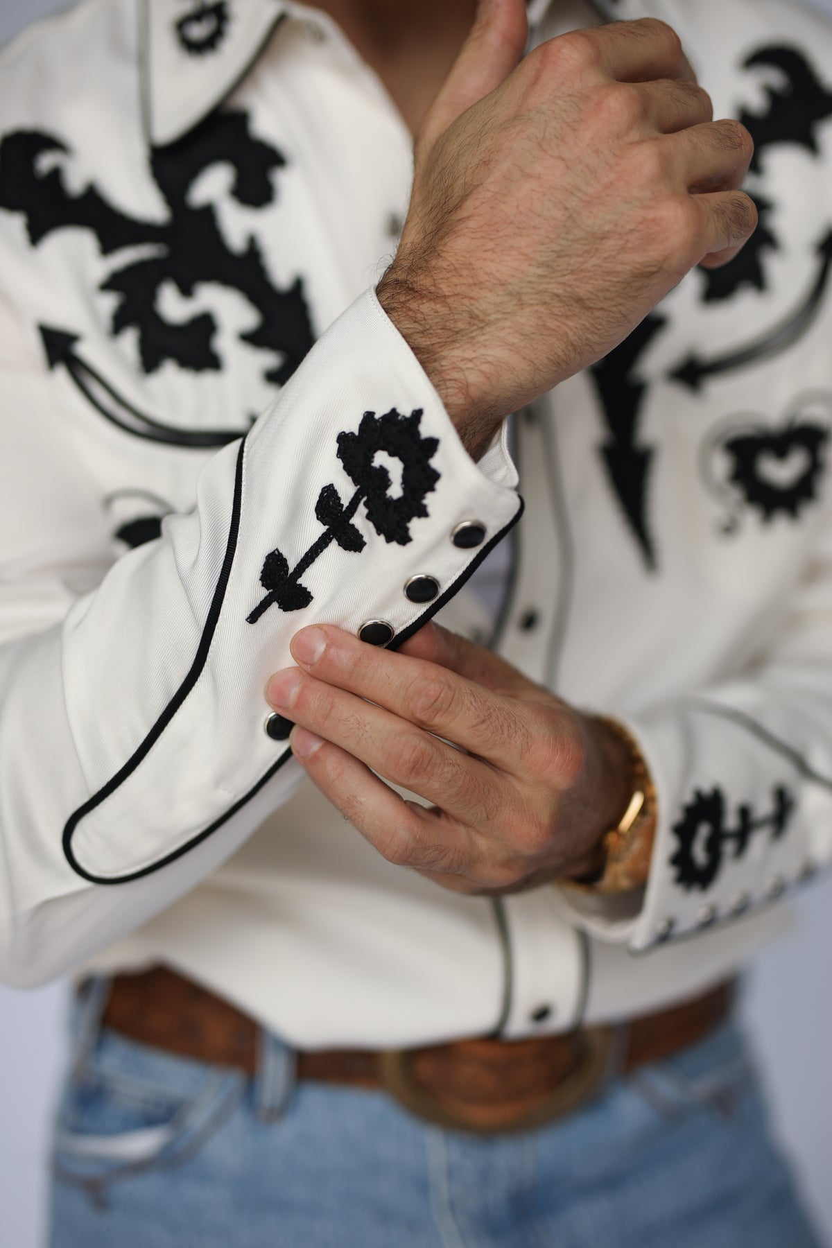Cuff close-up of the H Bar C Dali white shirt with black embroidery and piping.
