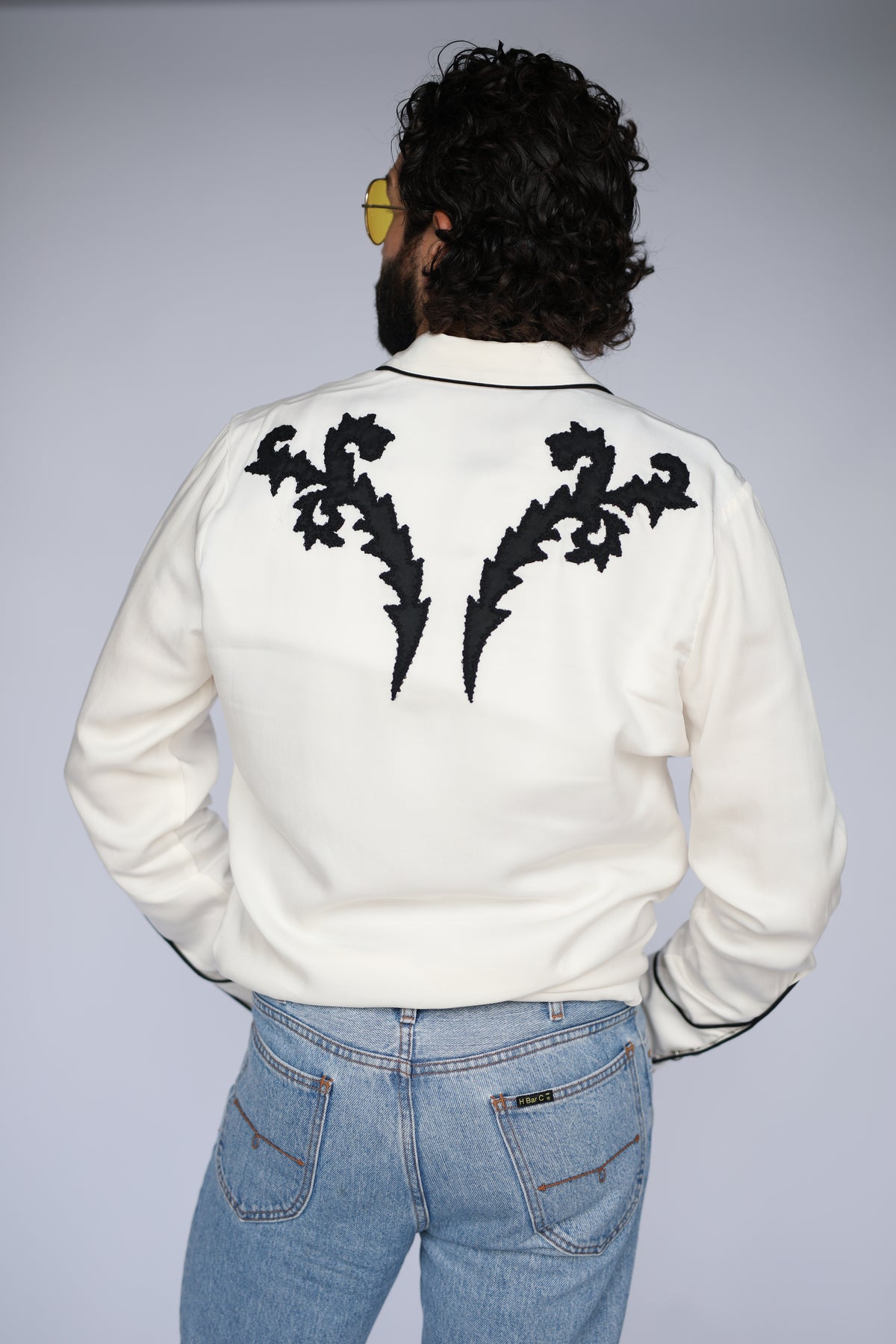 Back view of the H Bar C Dali white western shirt with black flame embroidered back yoke.