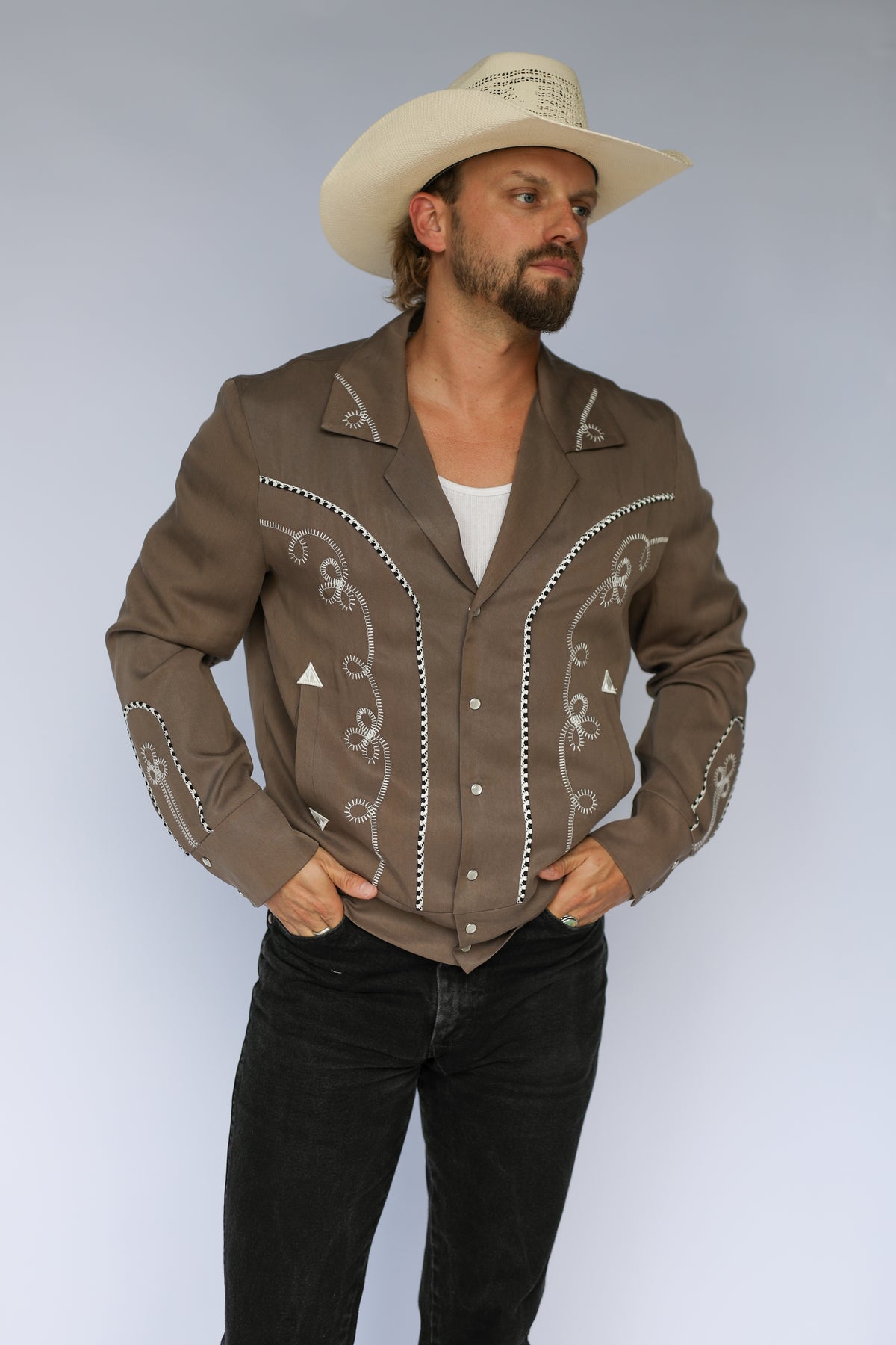 H Bar C Bolero cocoa and white western jacket with horseshoe appliqué and white piping, worn open.
