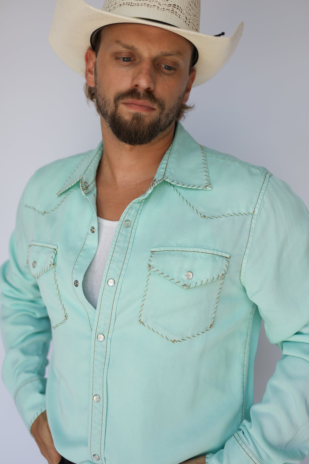 Close-up of a man in the H Bar C Brooklyn turquoise western shirt open at the collar.