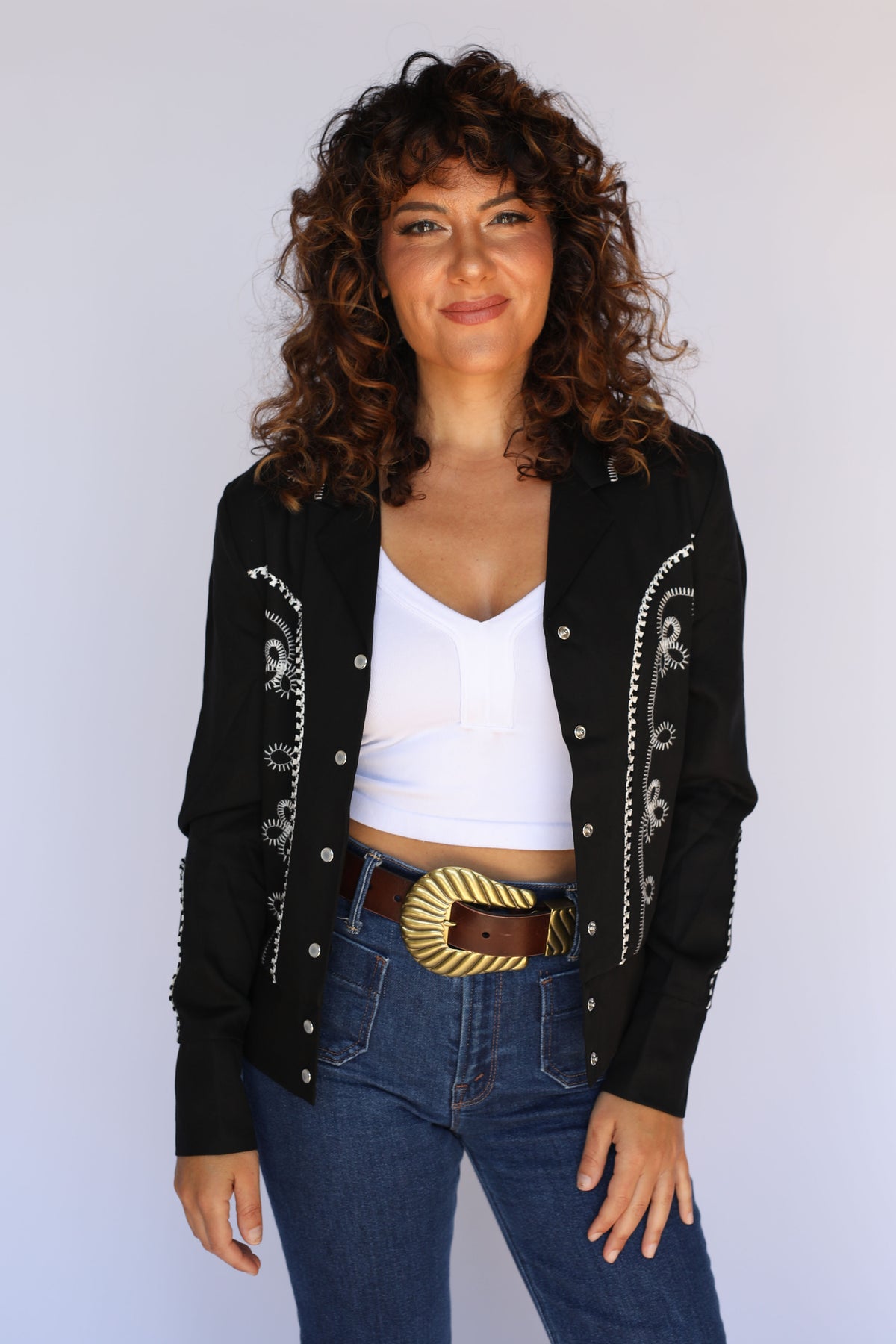 Woman wearing the H Bar C Bolero women's cropped western jacket in black with white piping, vintage inspired western wear.