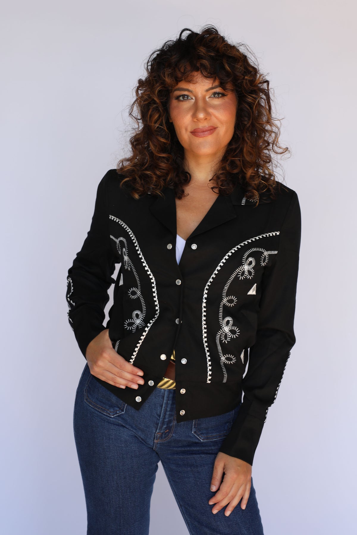 Model in the H Bar C Bolero women's black jacket styled with high-waist jeans and a gold buckle, vintage inspired western wear.
