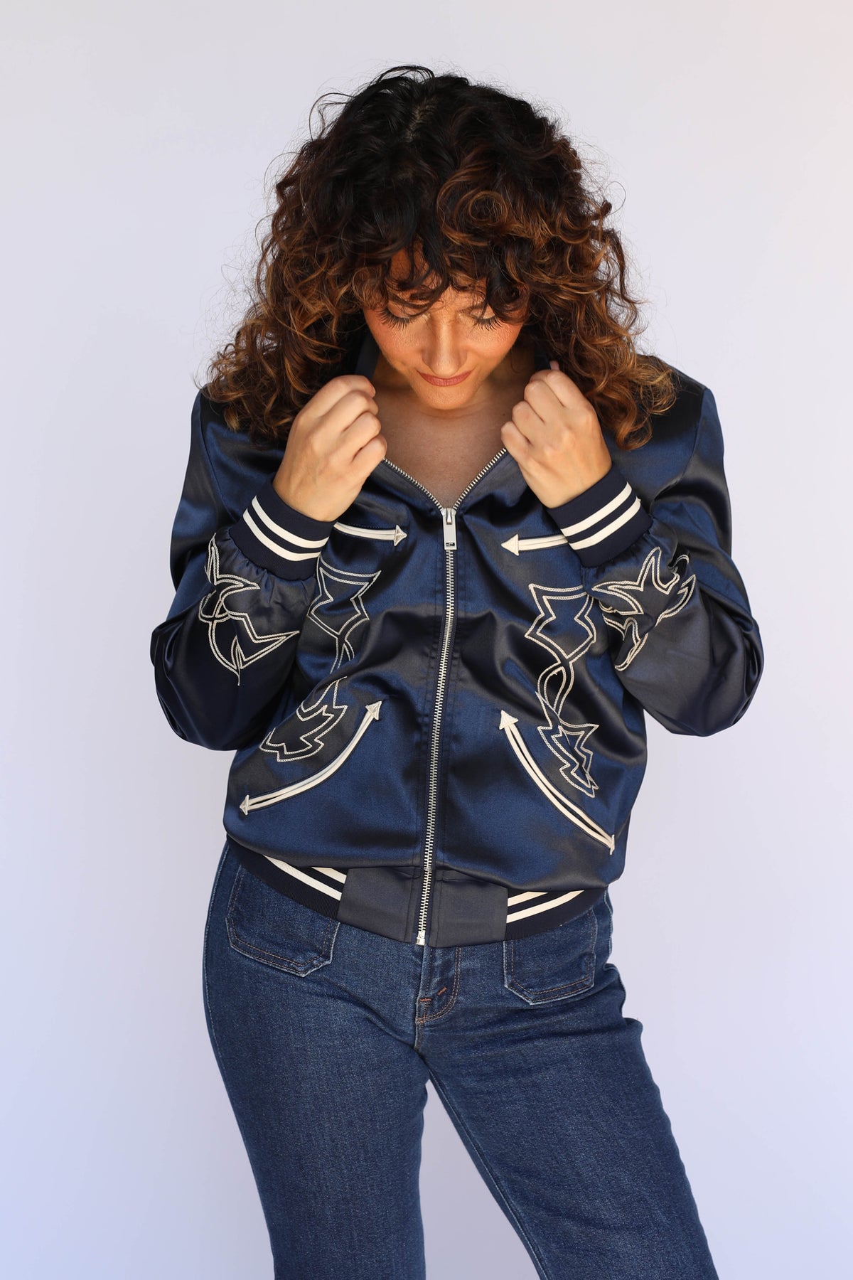 Woman in the H Bar C Odessa navy satin tour jacket with hands in her hair, unisex vintage western wear.
