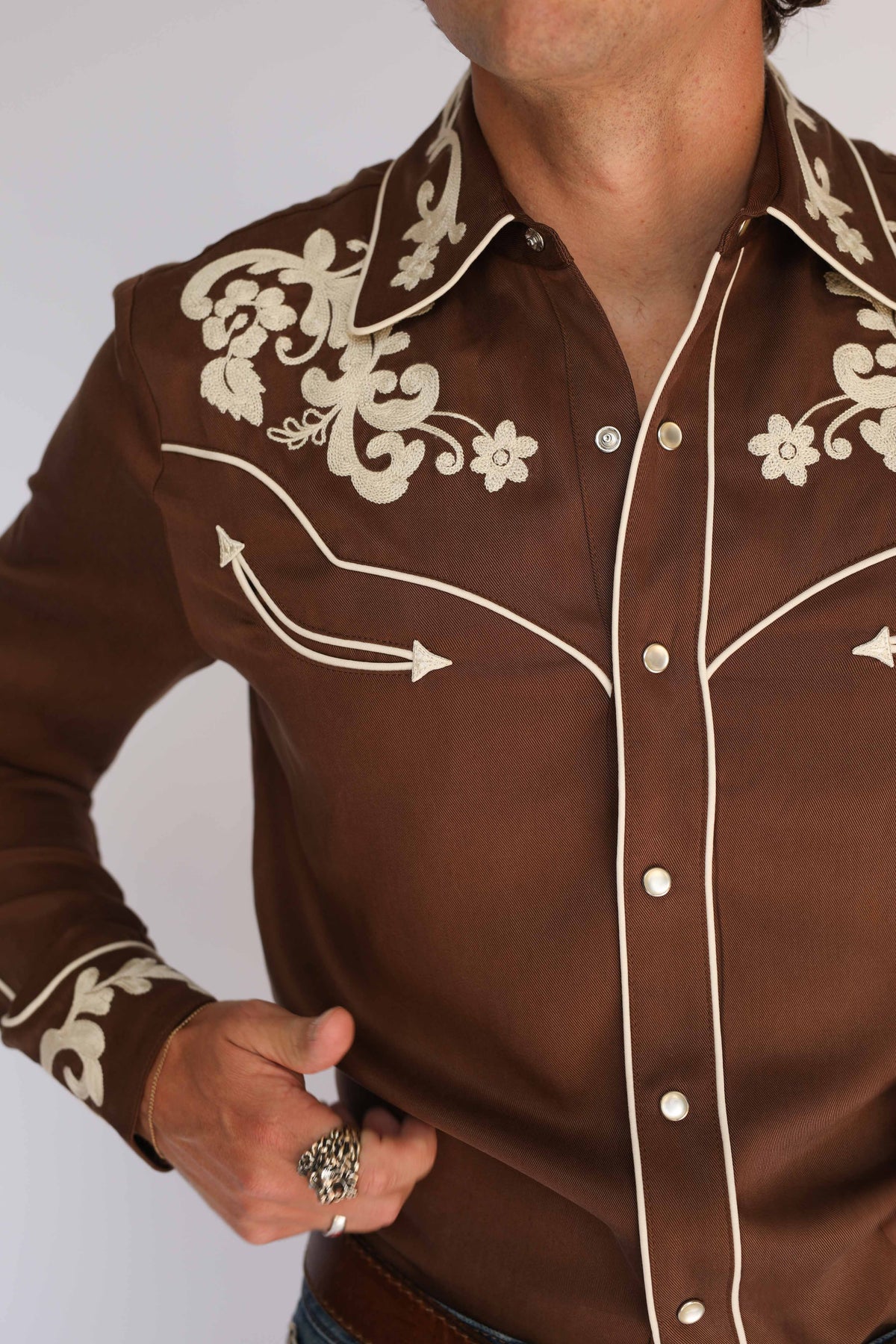 Side view detail of the H Bar C Durango brown shirt, vintage inspired western wear with cream embroidery along the yoke and sleeve.