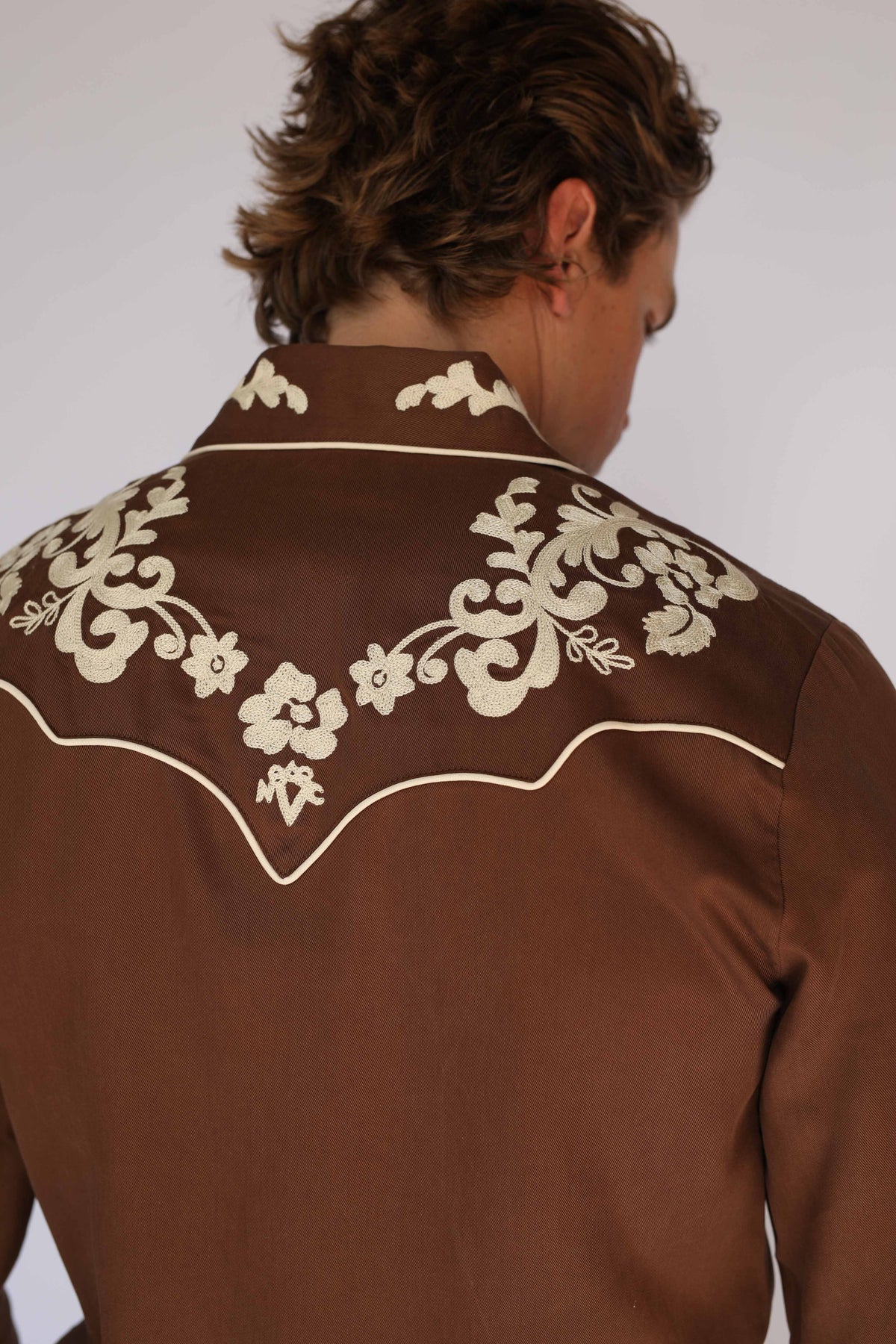Close-up of the cream chain stitch embroidery on the back yoke of the H Bar C Durango brown shirt, a vintage western wear detail.