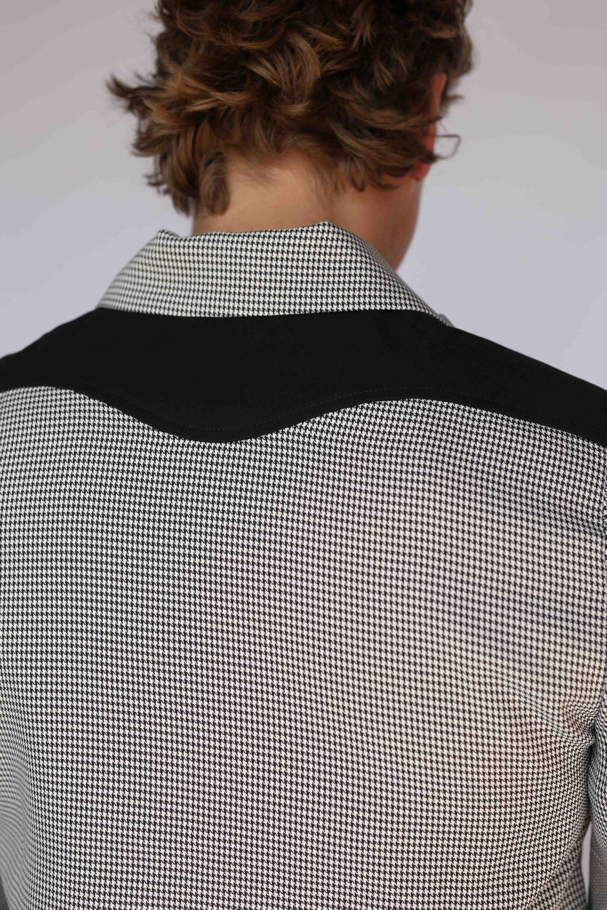 H Bar C Kentucky jacket in black houndstooth with black suede western yoke, zip front, and ribbed waistband, worn by a model
