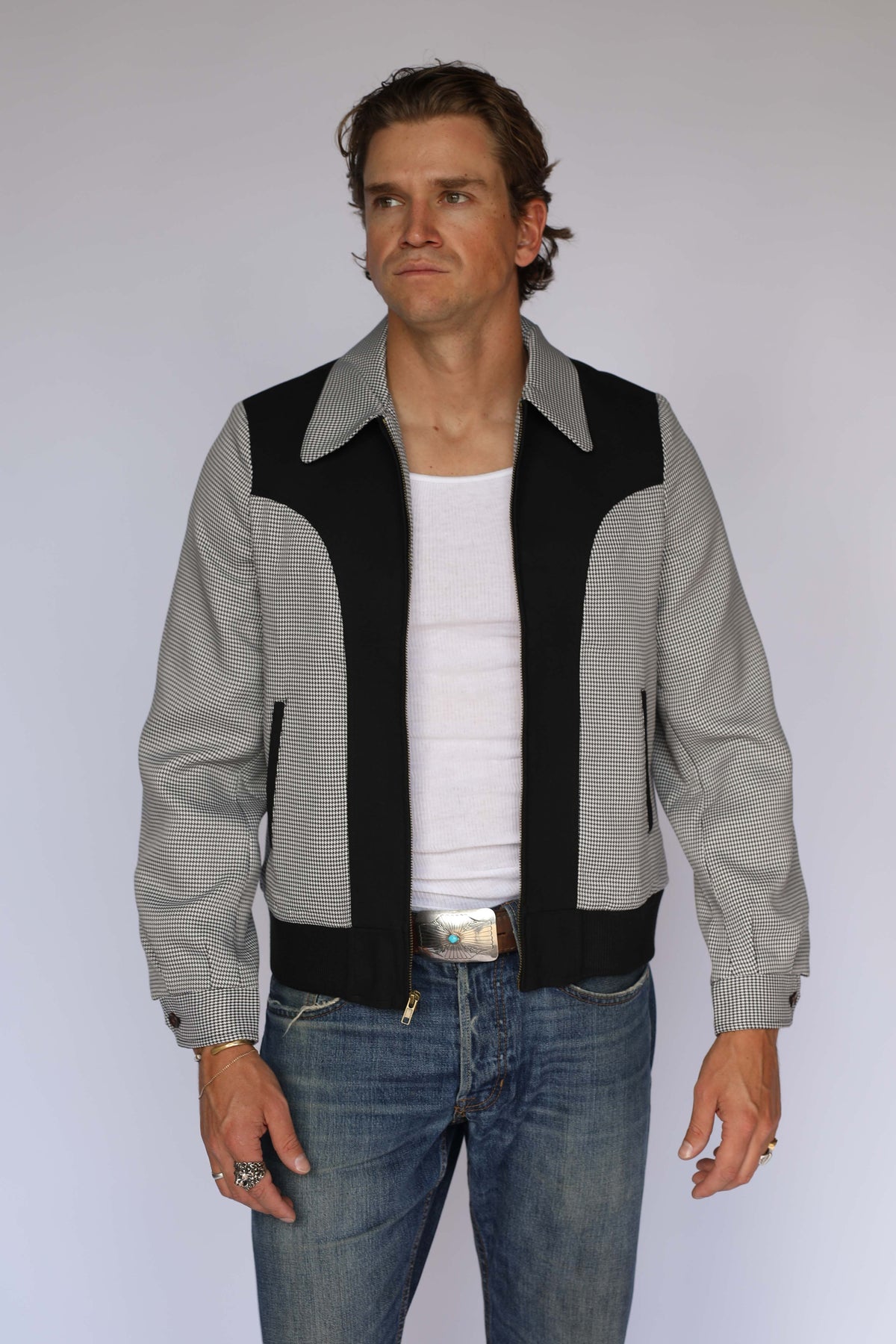 H Bar C Kentucky jacket in black houndstooth with black suede western yoke, zip front, and ribbed waistband, worn by a model