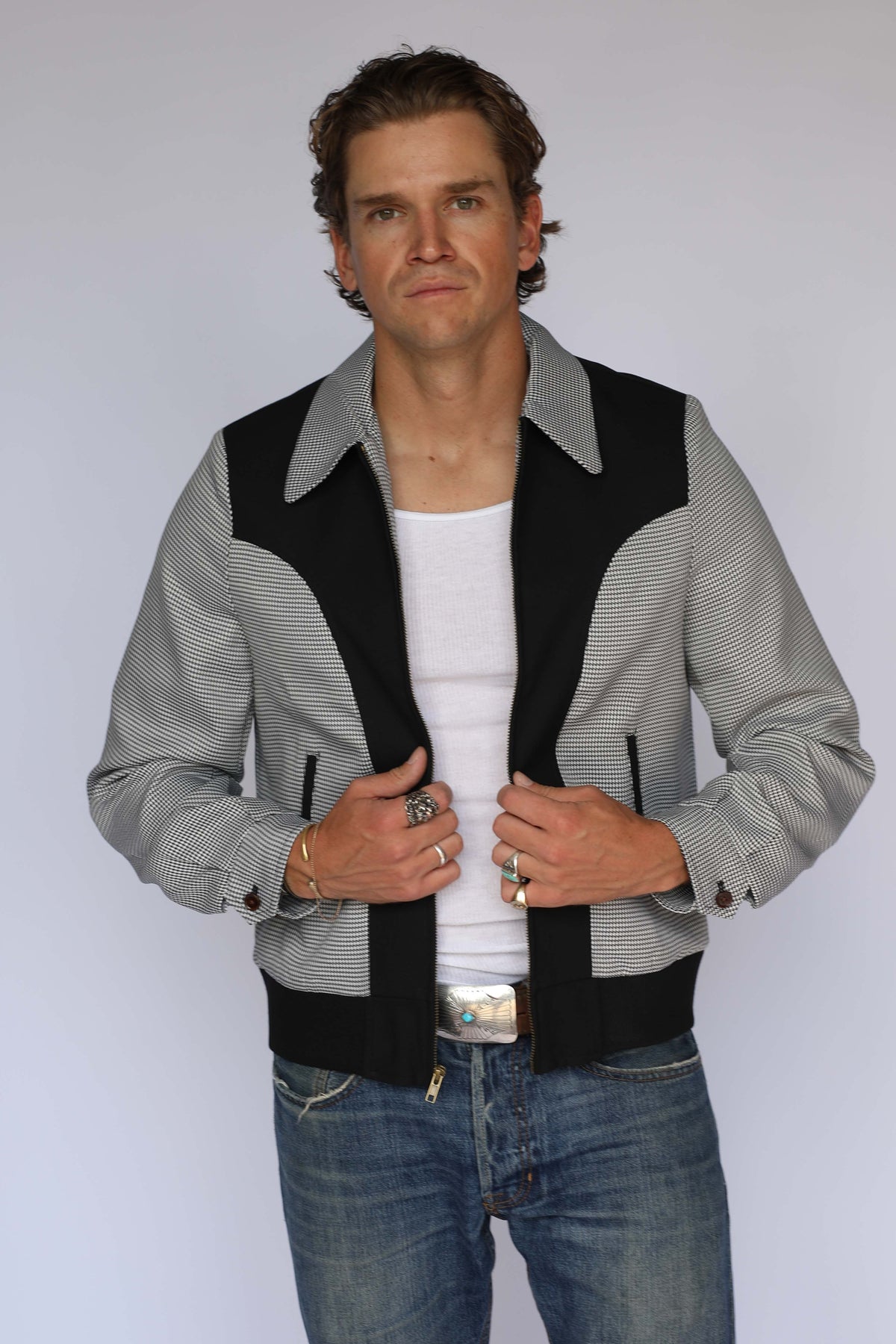H Bar C Kentucky jacket in black houndstooth with black suede western yoke, zip front, and ribbed waistband, worn by a model