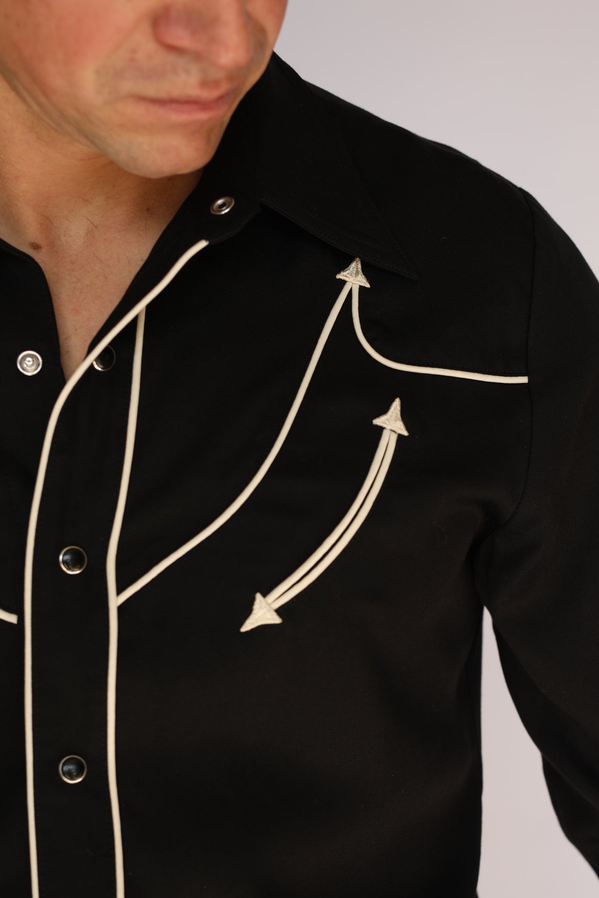 Side detail of the H Bar C Reno black shirt showing off-white piping and arrow embroidery on the yoke and sleeve, vintage western wear.
