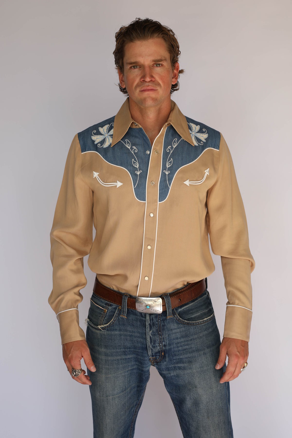 Model in the H Bar C Telluride two-tone western shirt, vintage western wear with embroidered denim yoke, tucked into jeans with a silver concho buckle.