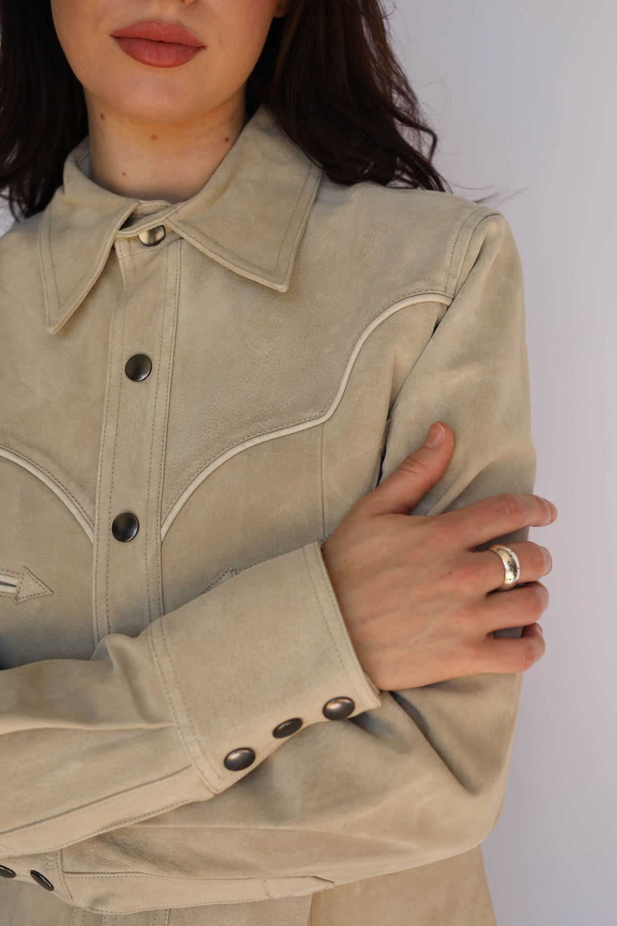 Close-up of the H Bar C Austin stone western jacket with button front, worn by a woman with arms crossed.
