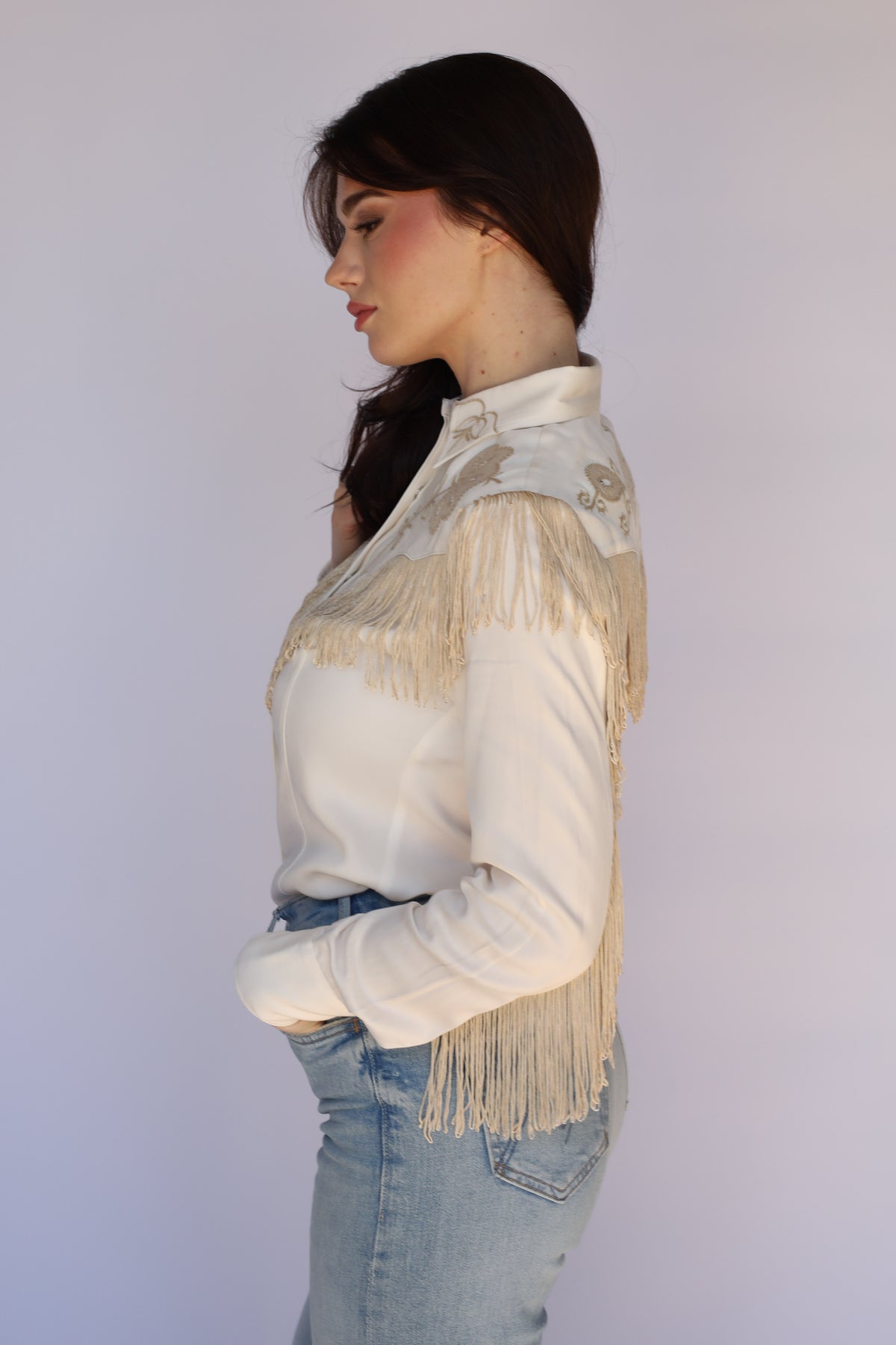 Side profile of the H Bar C Taos white fringe western shirt for women.