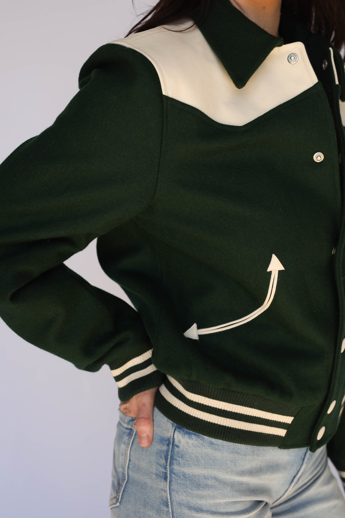 Close-up of the arrow pocket and striped cuff on The Vail green jacket by H Bar C.