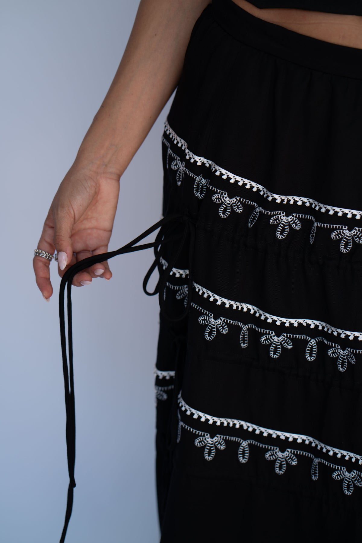 Close-up of the tie tiers on the H Bar C Coachella black maxi skirt with white embroidery.