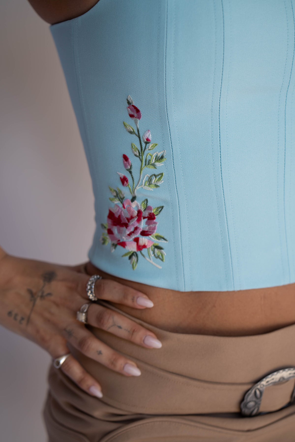 Close-up of the pink rose embroidery on the side of the H Bar C Abilene blue corset.