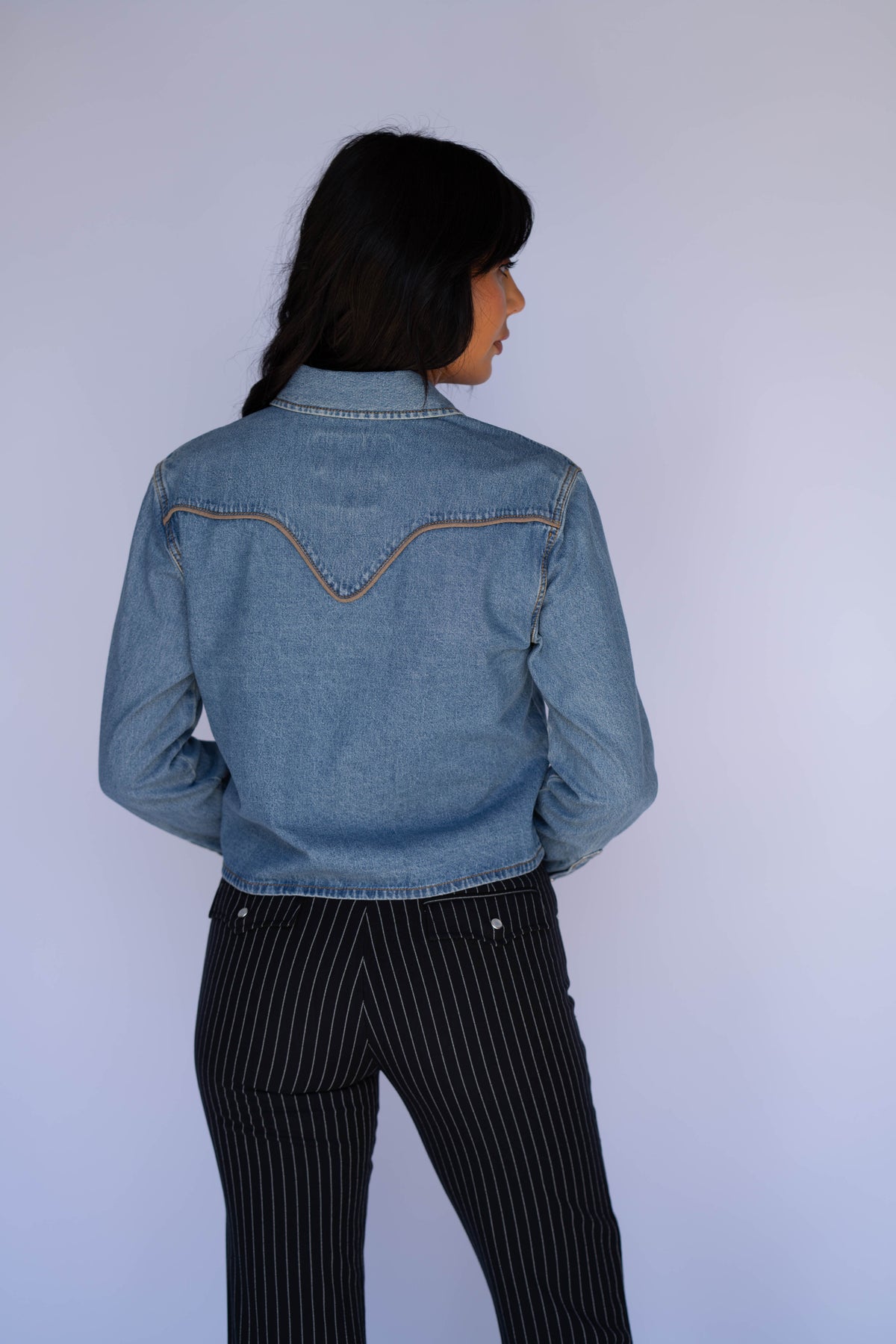 Back view of the Rustler x H Bar C women's denim cropped shirt with piped western back yoke.