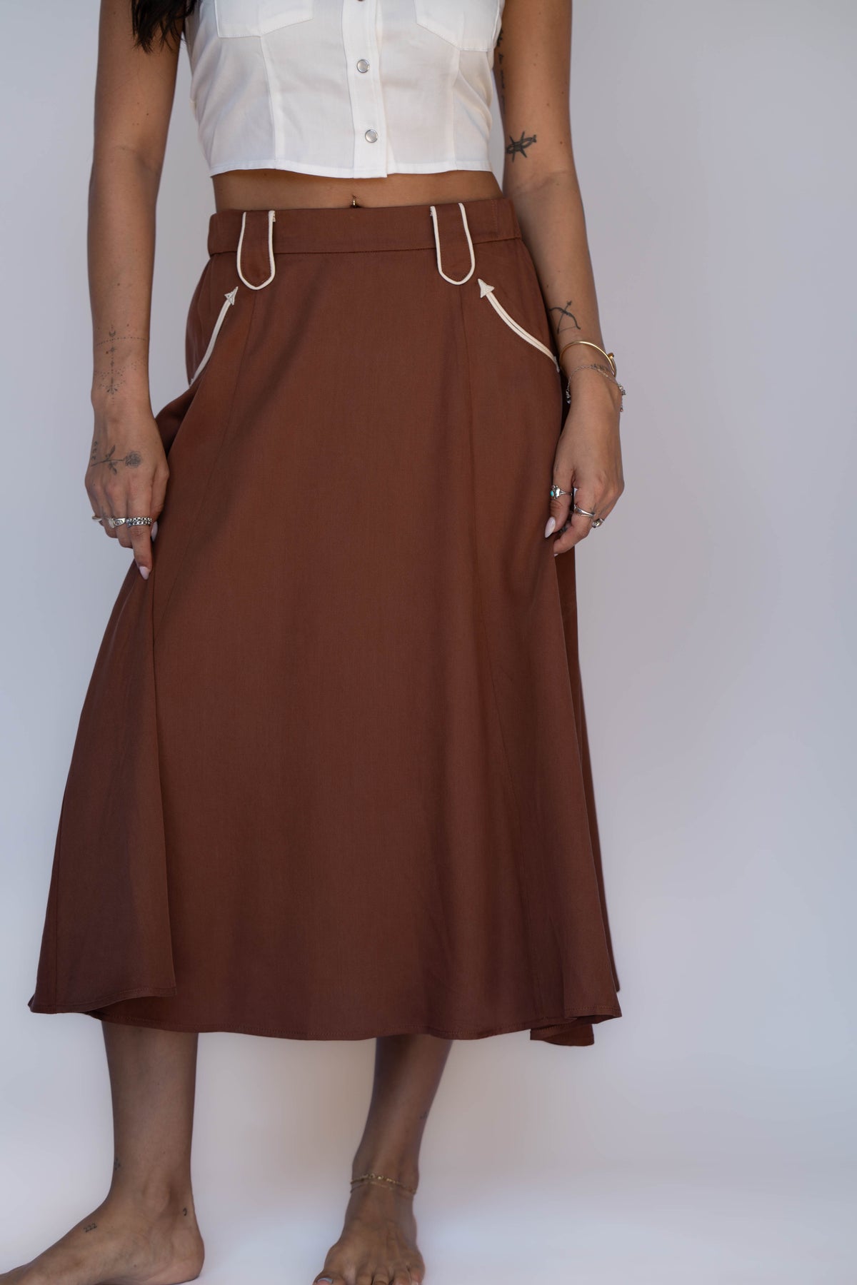 Front view of the H Bar C Santa Fe chocolate A-line skirt with banded waist and white piping.