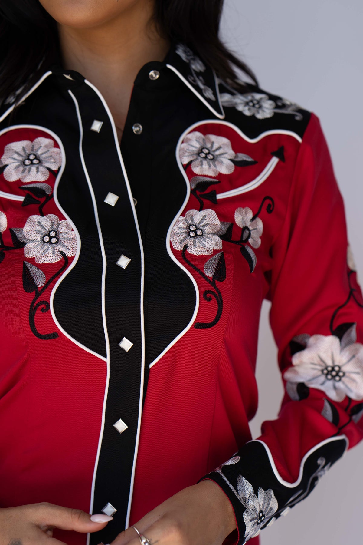 Close-up of the black yoke and white embroidered flowers on the H Bar C Santa Ana red women's shirt.