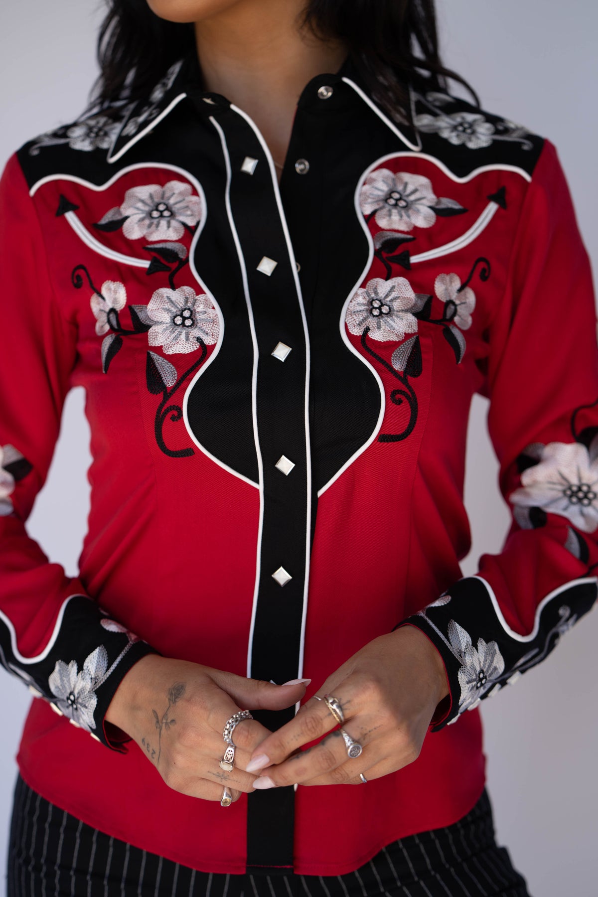 Front detail of the H Bar C Santa Ana red shirt with hand-detailed floral embroidery and piped black yokes.