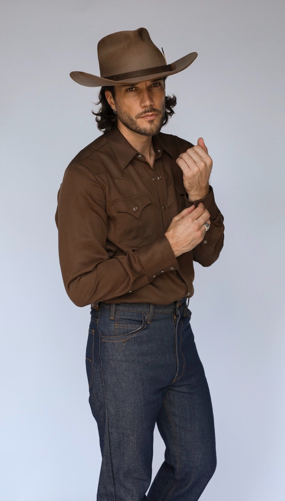Full length three-quarter view of the H Bar C Denver chocolate brown shirt with dark jeans and cowboy hat.