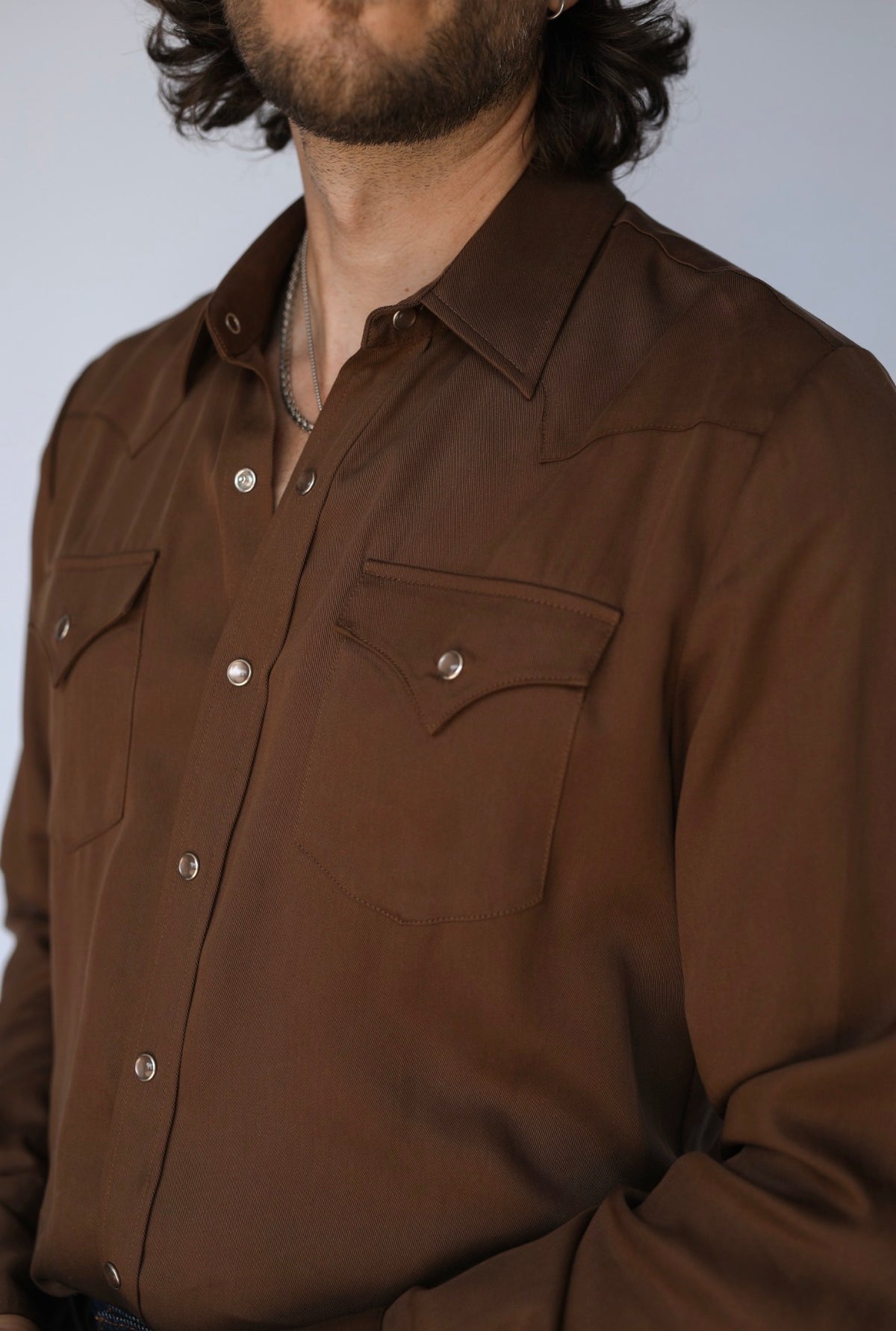 Close-up of the pointed flap pocket and pearl snaps on the H Bar C Denver chocolate western shirt.
