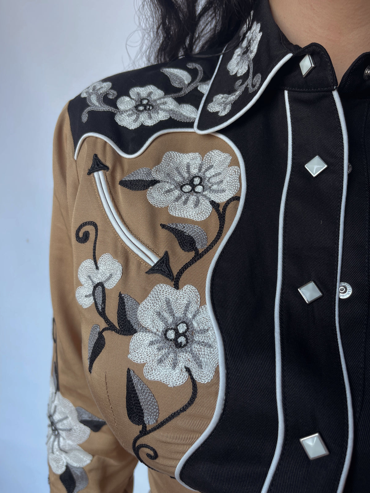 Detail of the white embroidered flowers on black yoke of the H Bar C Santa Ana tan shirt.