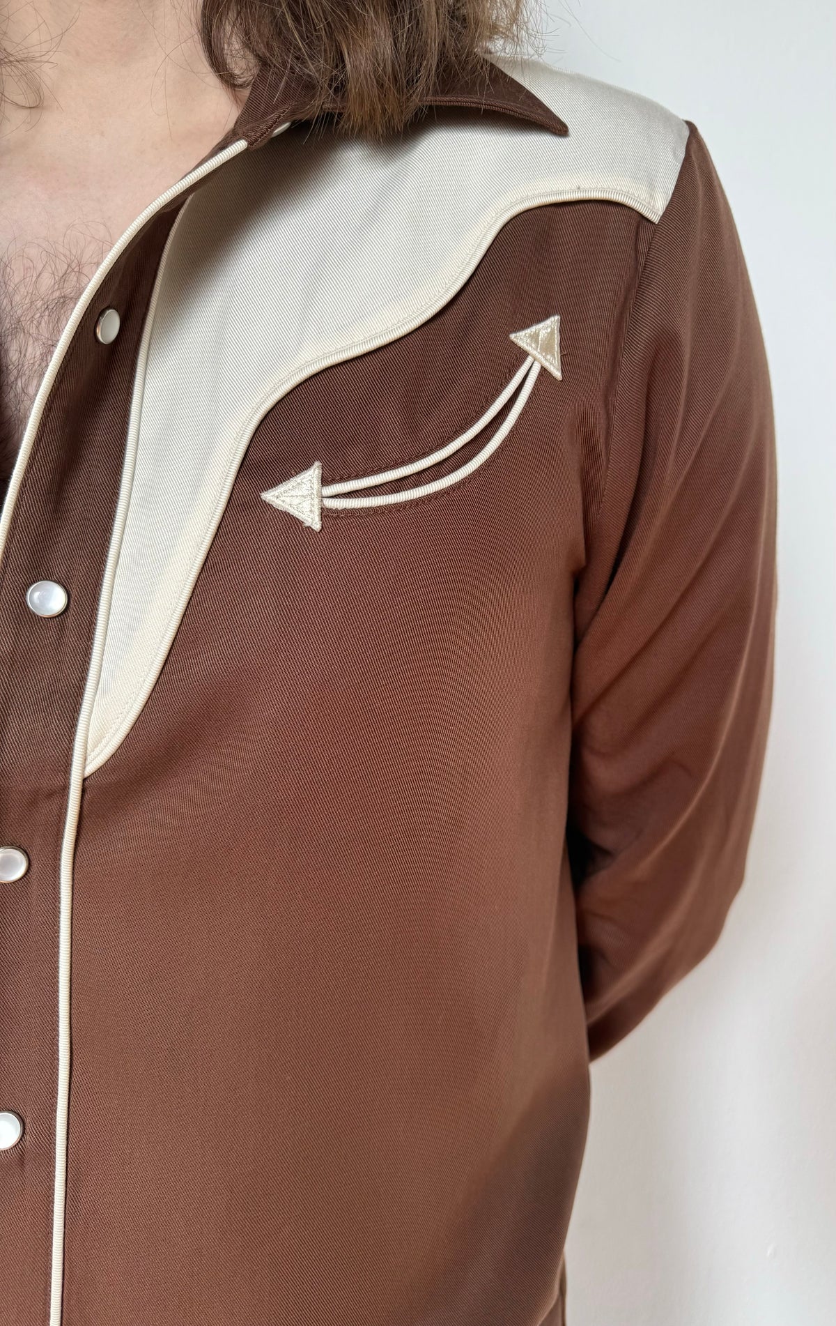 Close-up of the off-white yoke with embroidered arrow on the H Bar C San Juan chocolate Tencel shirt.