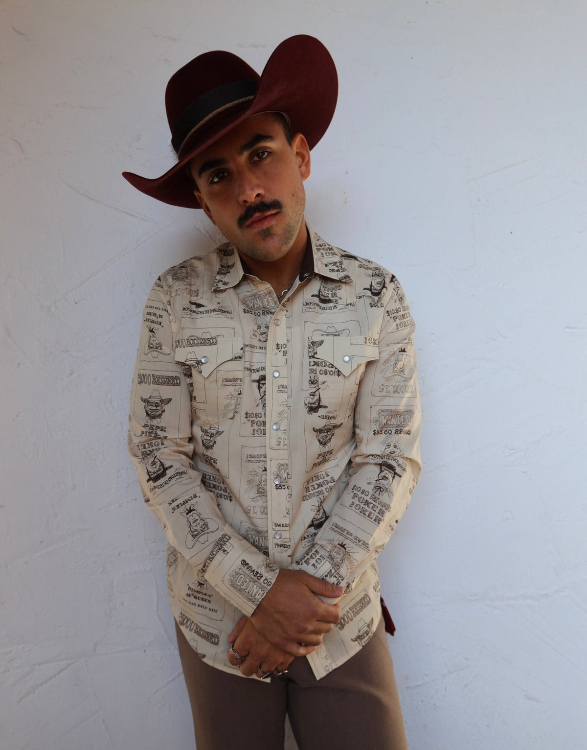 Front view of the H Bar C Tumbleweed beige printed western shirt with brown pants and buckle.