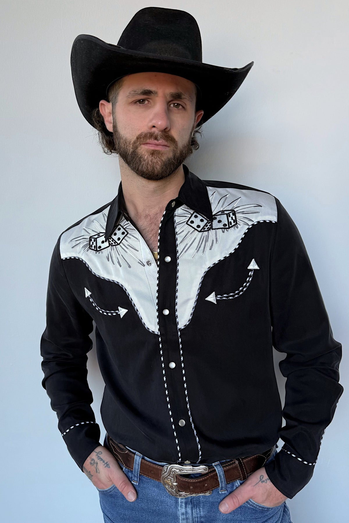 Man in a black cowboy hat wearing the H Bar C Jillette shirt in black with white embroidered yokes, an original H Bar C archive design.