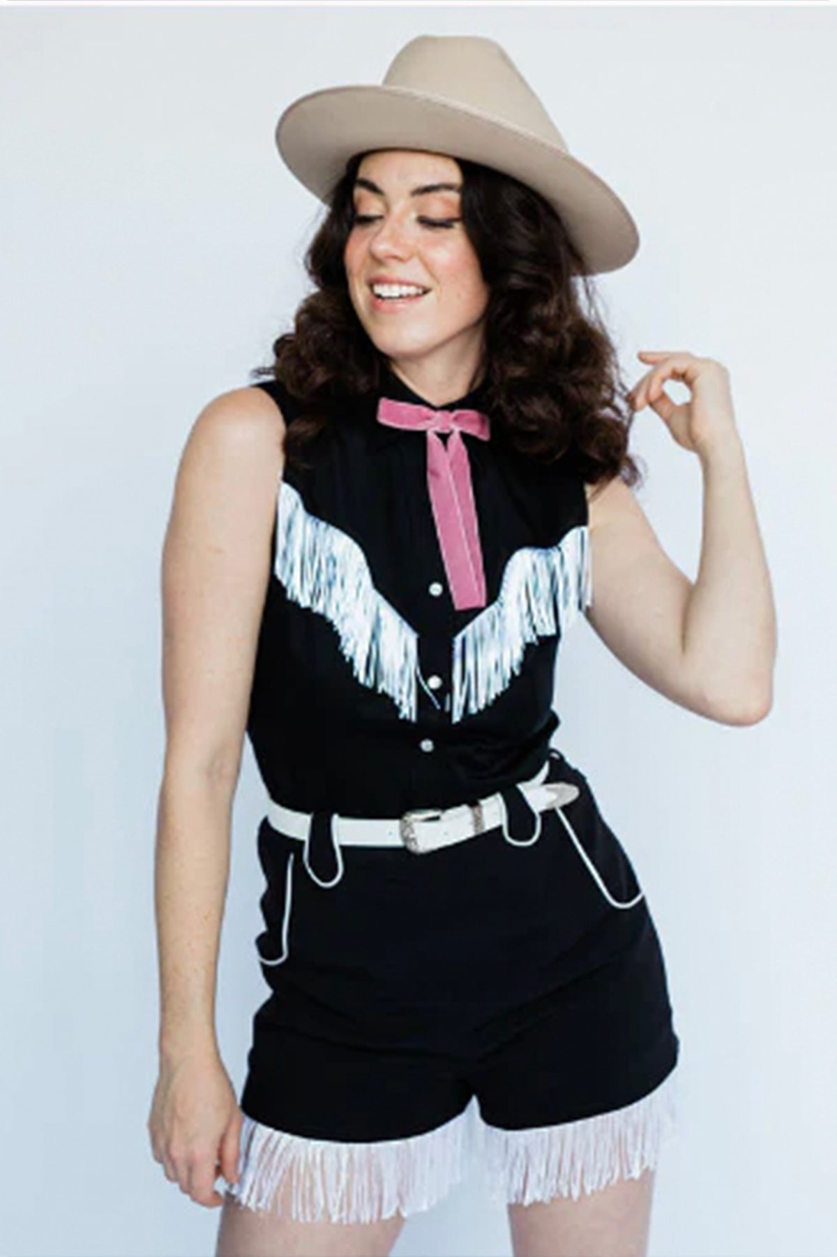 Woman in a tan hat wearing the H Bar C Marfa women's shorts in black with white fringe, with the black Tulsa fringe shirt.