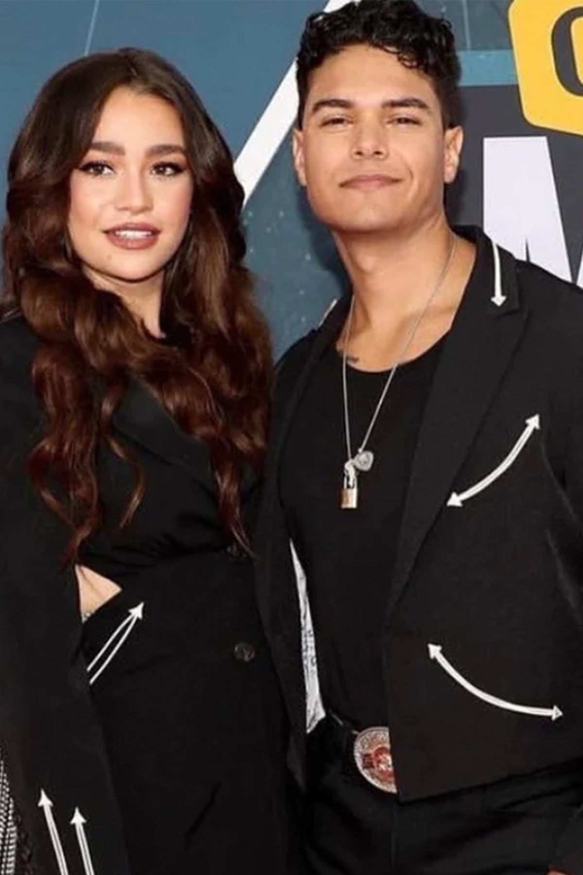Two people at an event wearing the H Bar C Phoenix and Calamity black jackets with white arrow trim.
